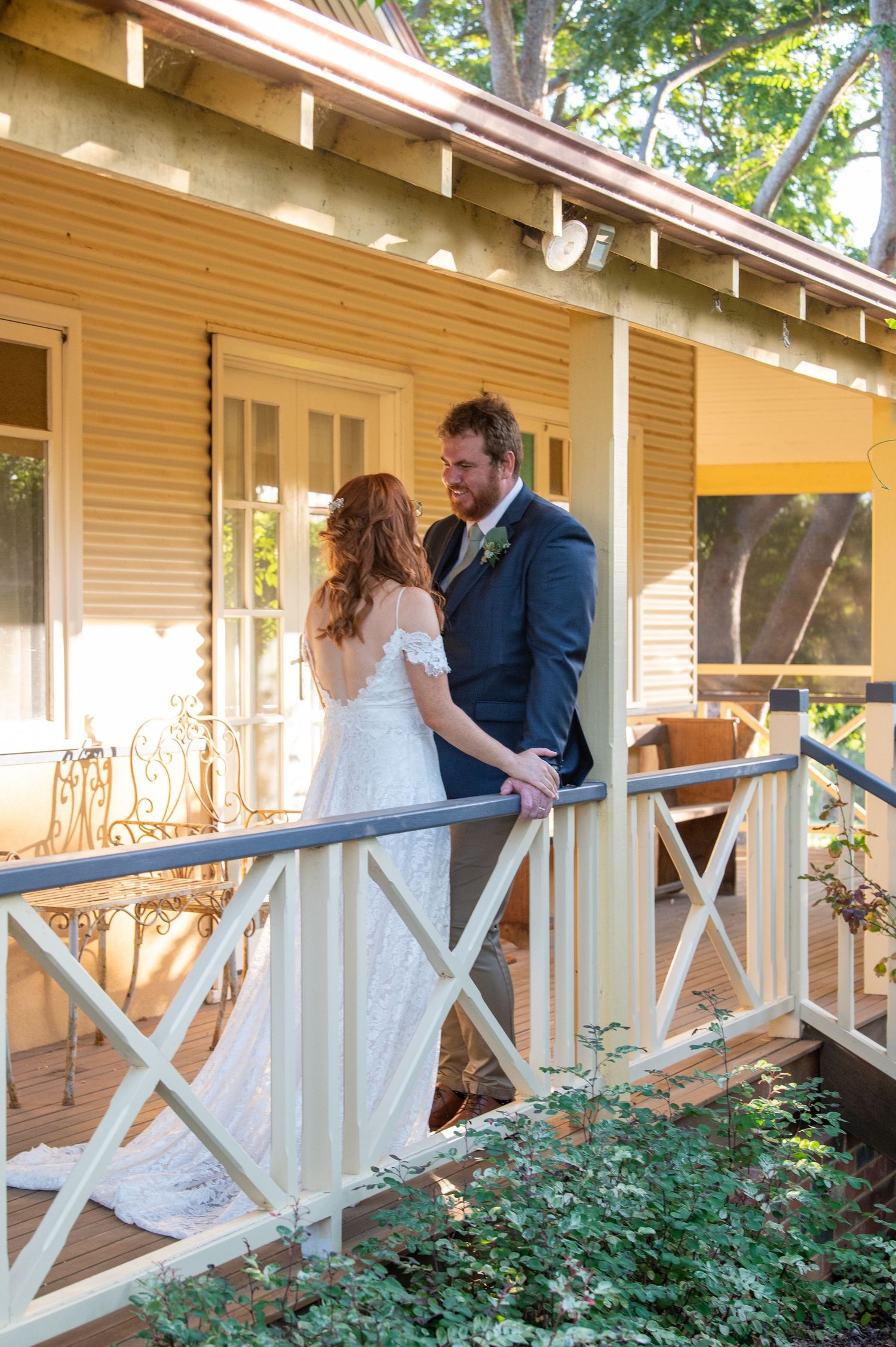 Romantic sequence of a couple embracing on a covered porch with white railings.