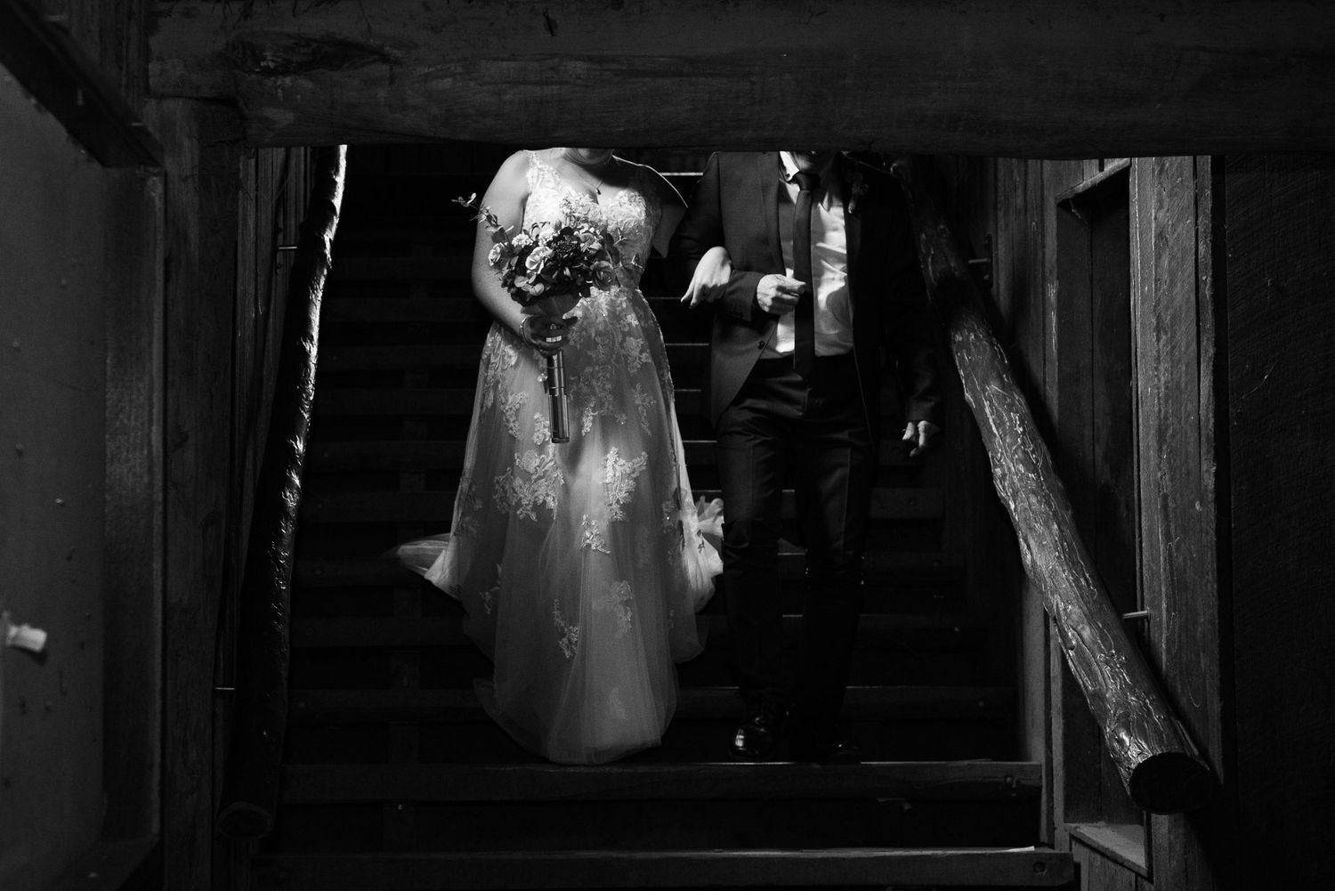 A black and white image of a ghostly figure standing on dark stairs in a horror scene setting.