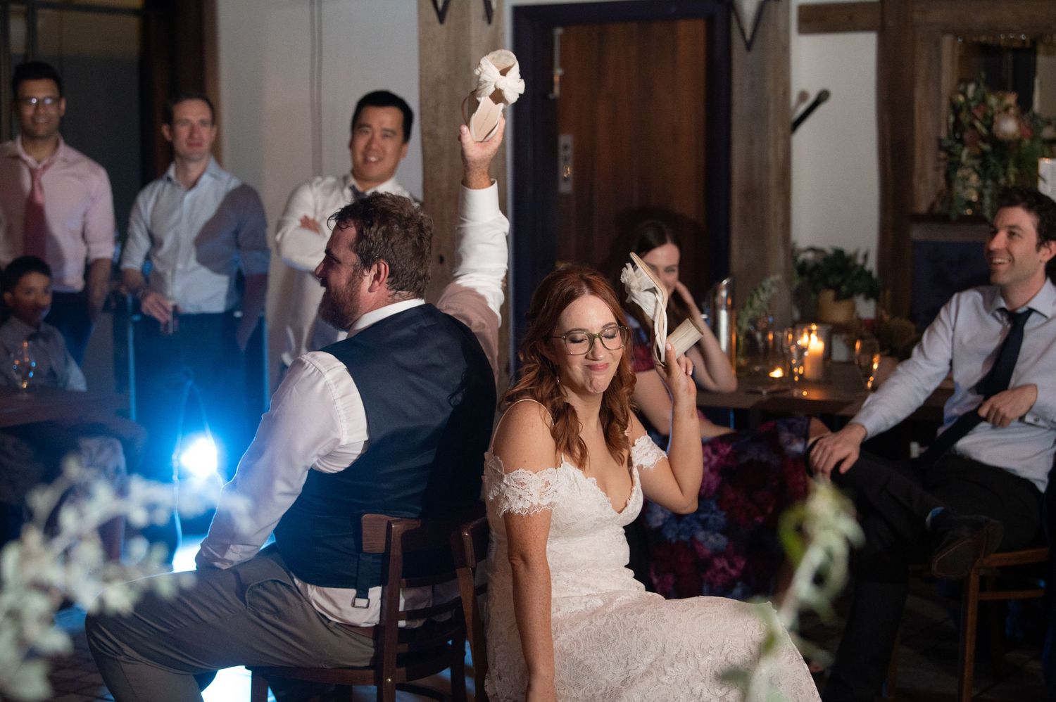 Wedding celebration with guests raising glasses during reception.