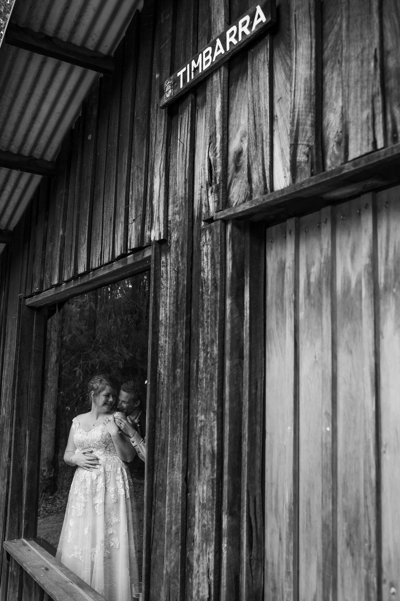 Black and white architectural photograph showing weathered corrugated metal walls with contrasting light and shadow patterns.