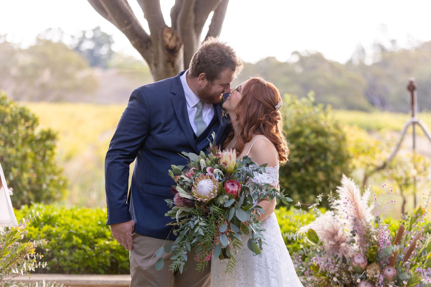 A romantic wedding moment captured in a garden setting with a beautiful floral bouquet.