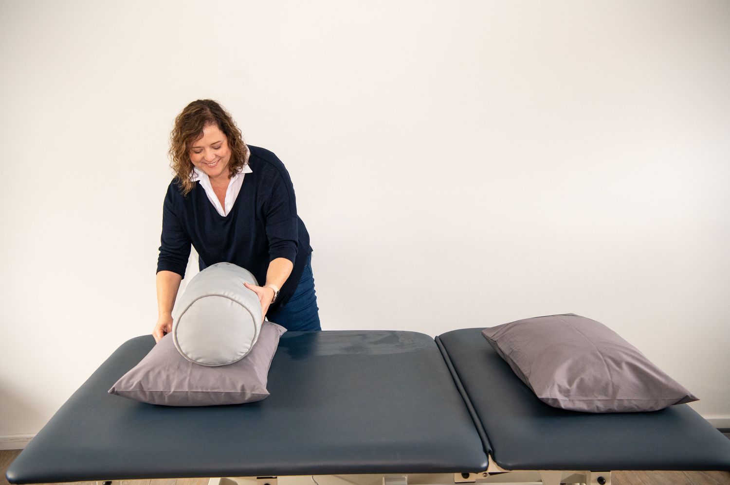 Four instructional steps showing how to insert pillows into shams on a dark mattress.