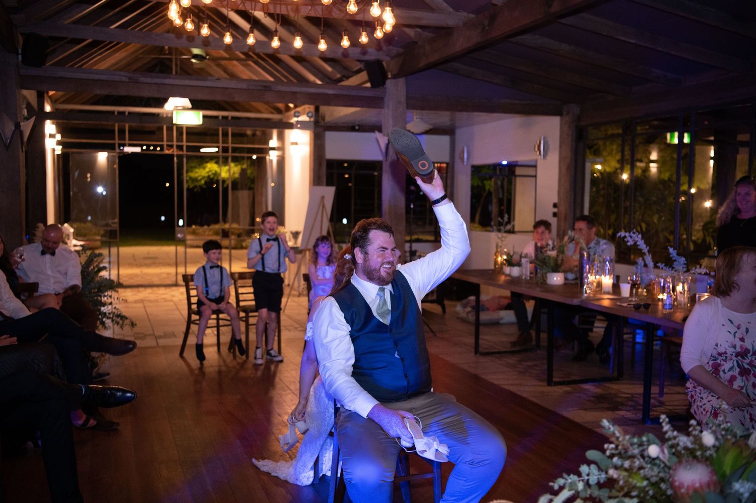 Lively wedding reception with celebratory dancing and raised arms.