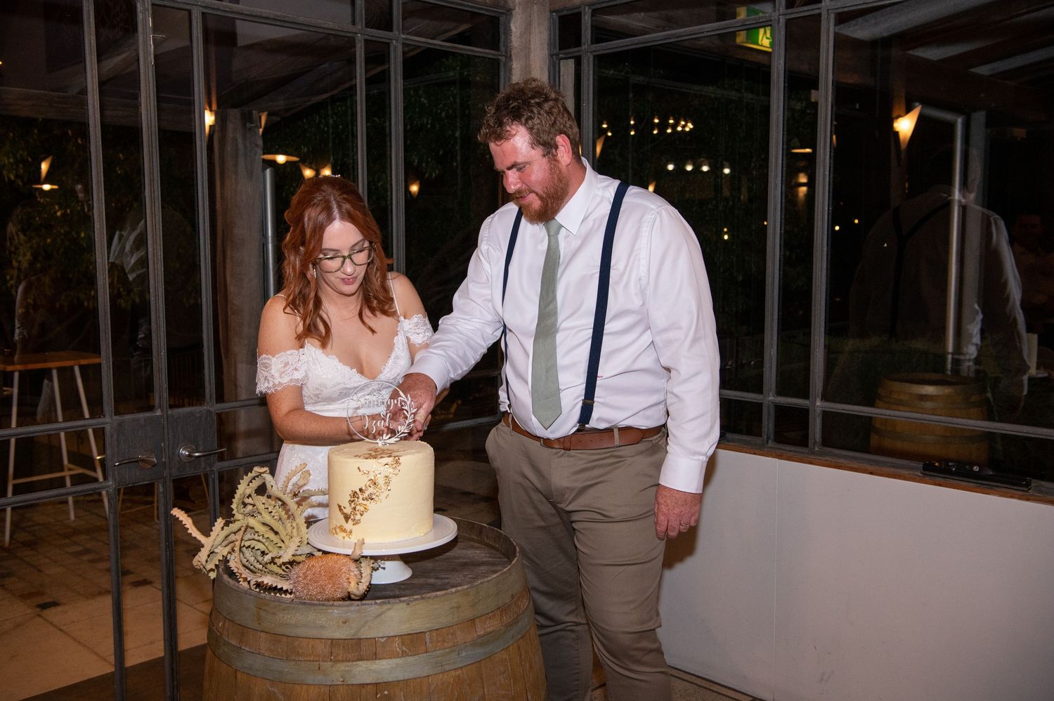 Wedding reception venue decorated with rustic barrels and ambient lighting.