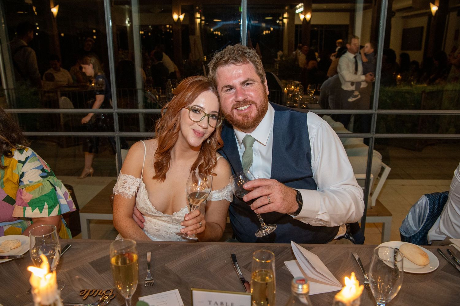 Reception dinner scene with candlelit tables and guests.