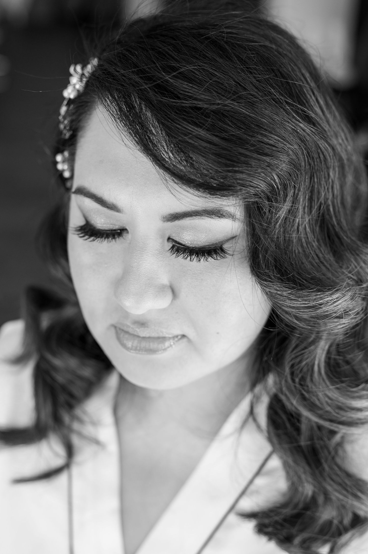 Black and white portrait showing elegant bridal makeup and wavy hair styled with delicate hair accessories.