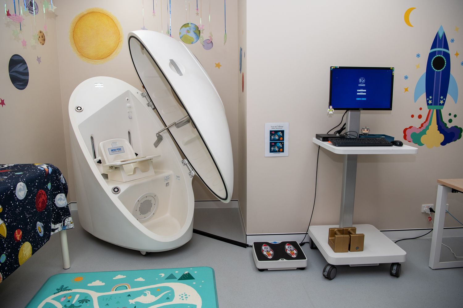 Medical facility hallway with hospital equipment and yellow moon decorations on the walls.