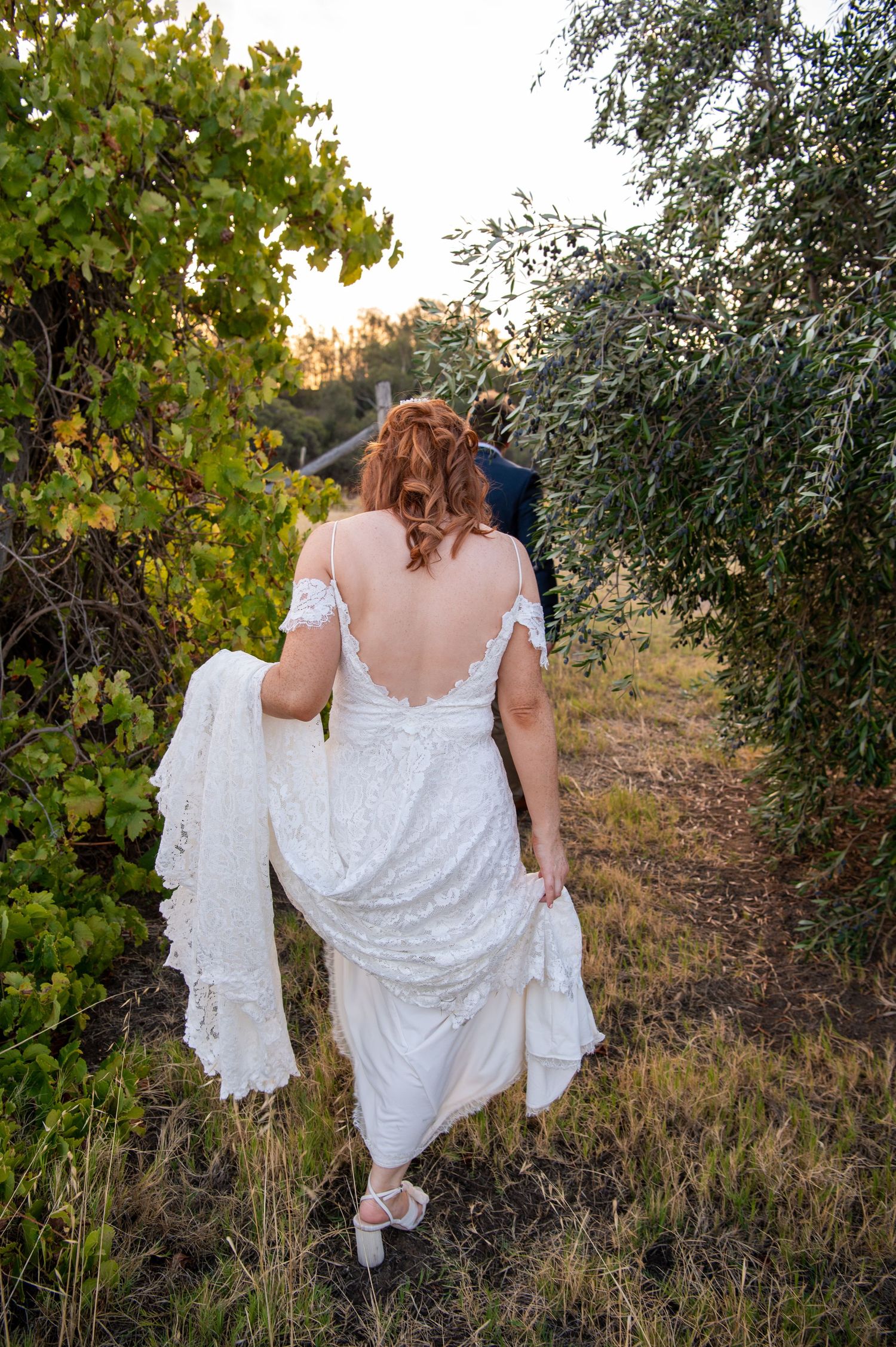 A romantic walk through nature showing the detailed back of a lace wedding gown.