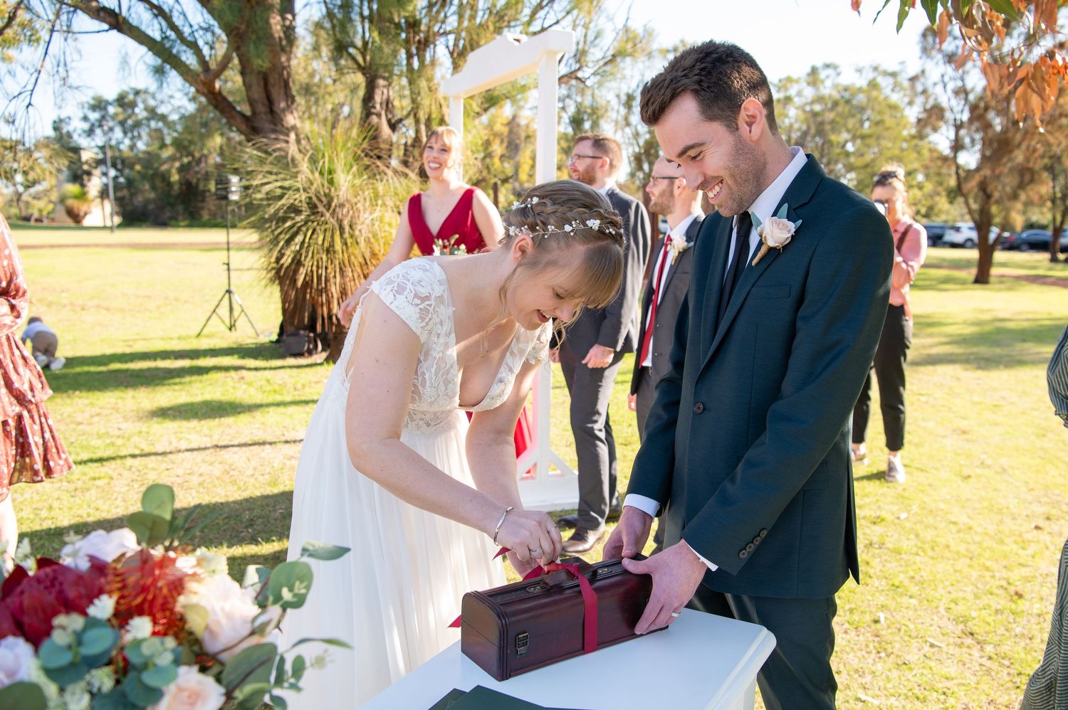 Couple participates in unity ceremony ritual during outdoor garden wedding.