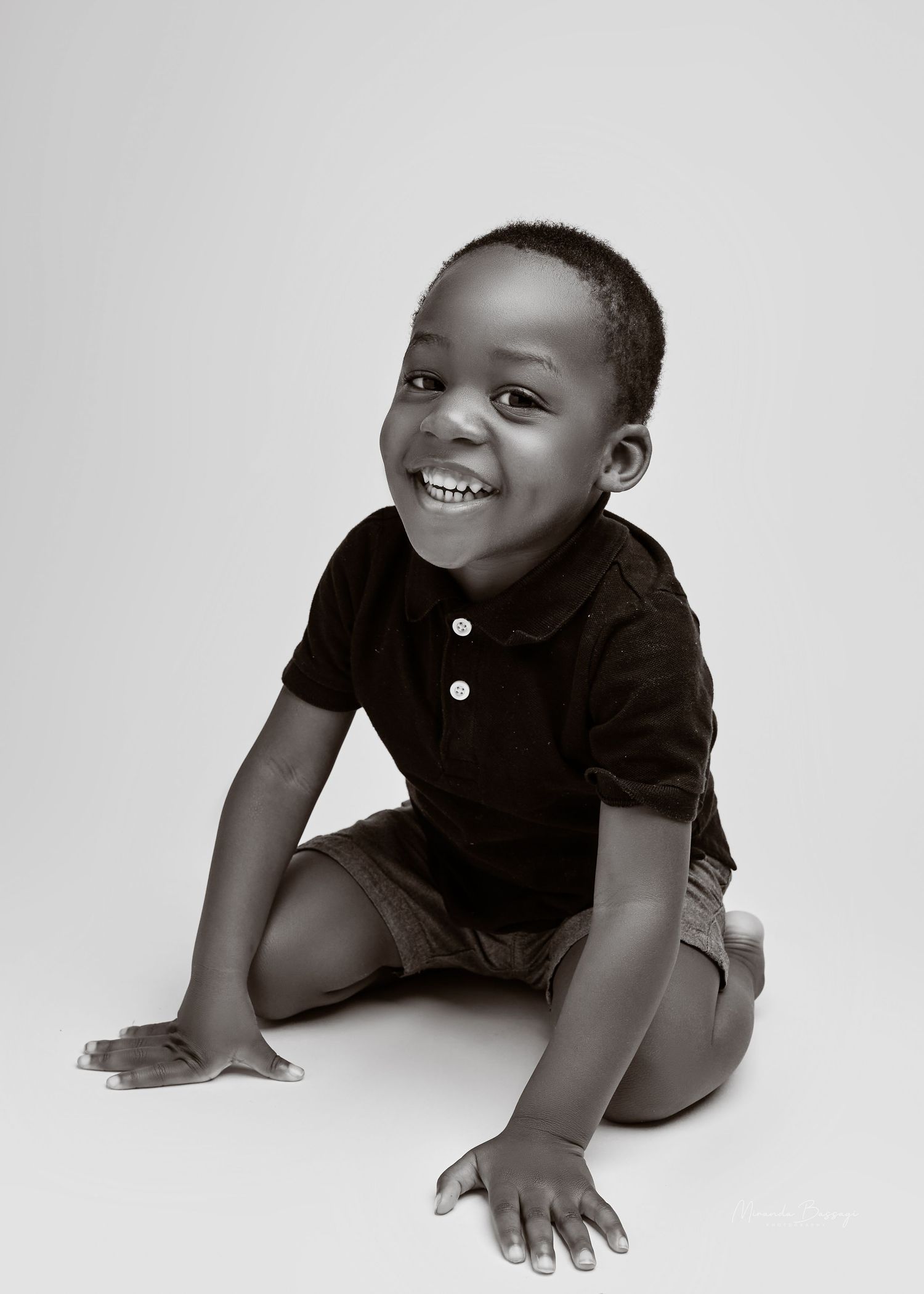 Black and white studio portraits capturing candid expressions of child in casual wear.