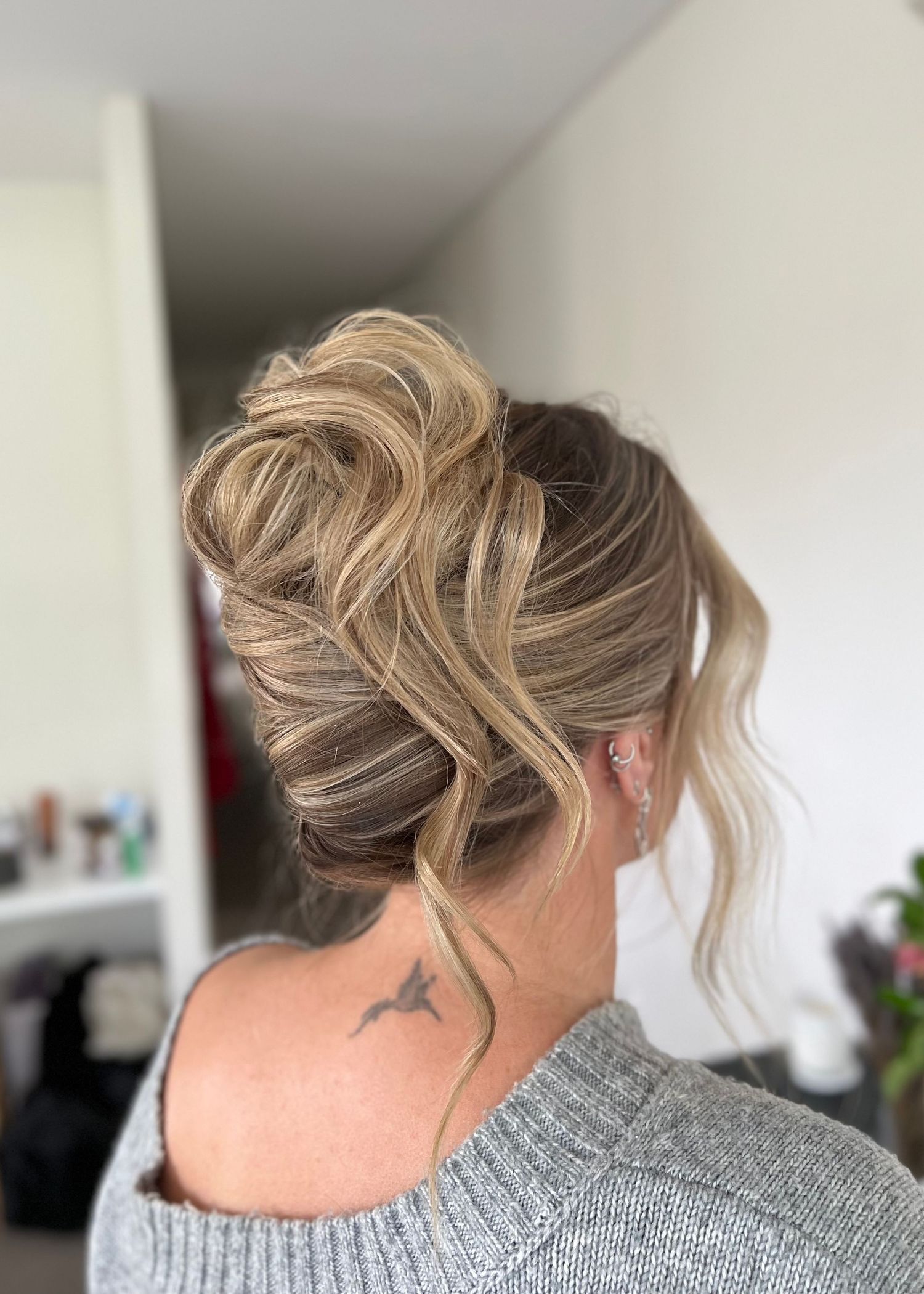 Elegant updo hairstyle with loose waves and wispy texture.