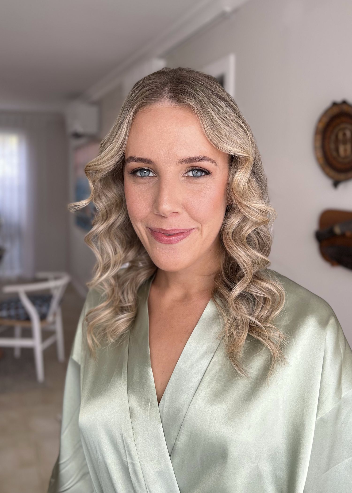 Polished beauty look with wavy blonde hair and mint green silk robe.