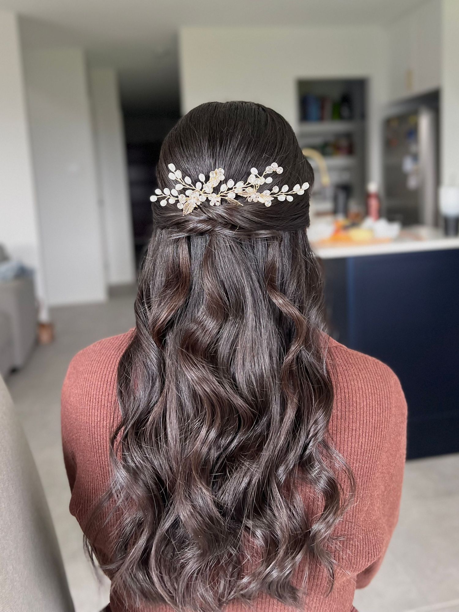 Dark brown wedding hairstyle with delicate braids and floral hairpiece.