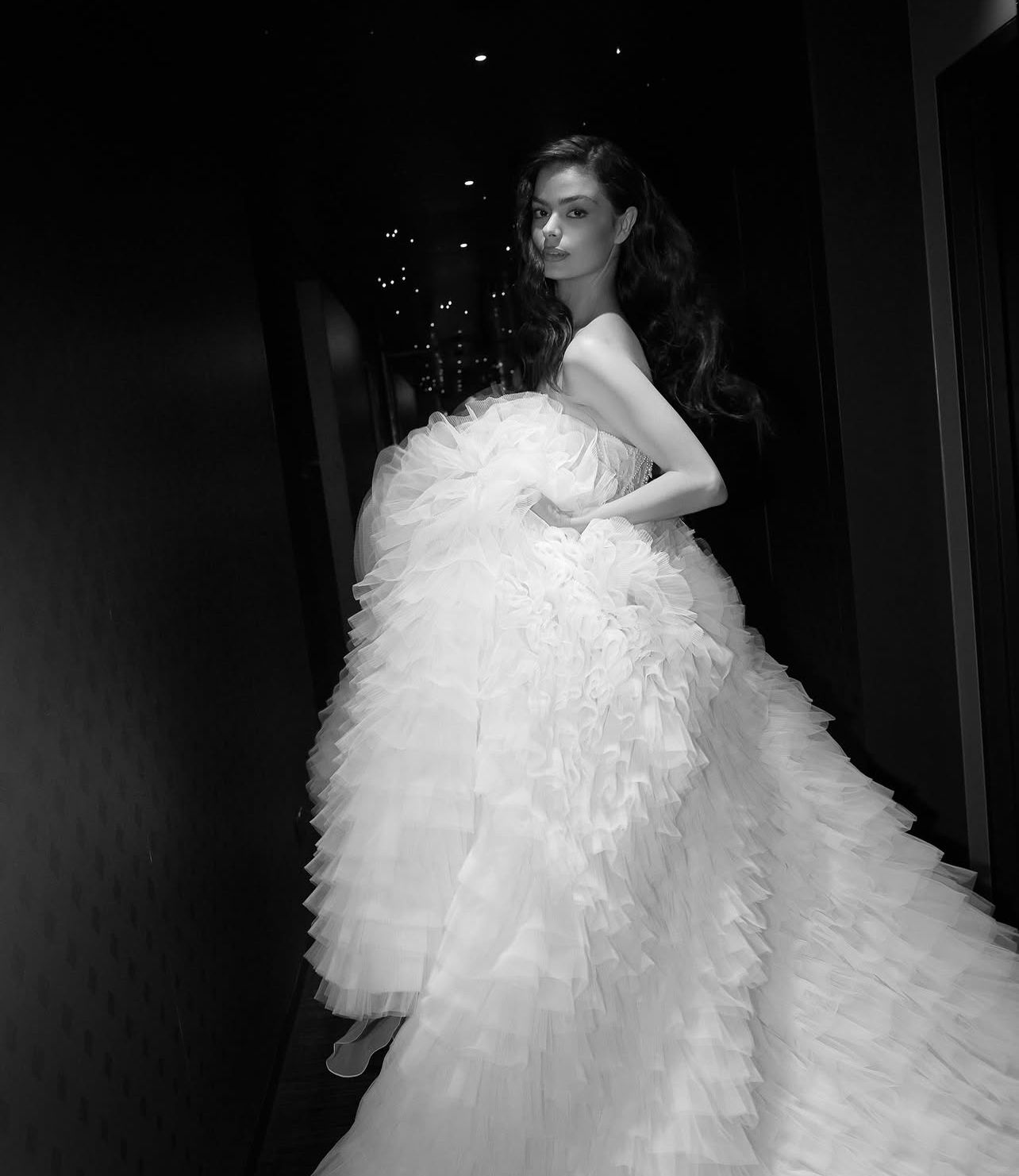 A dramatic black and white photo showcasing a voluminous tulle wedding gown.