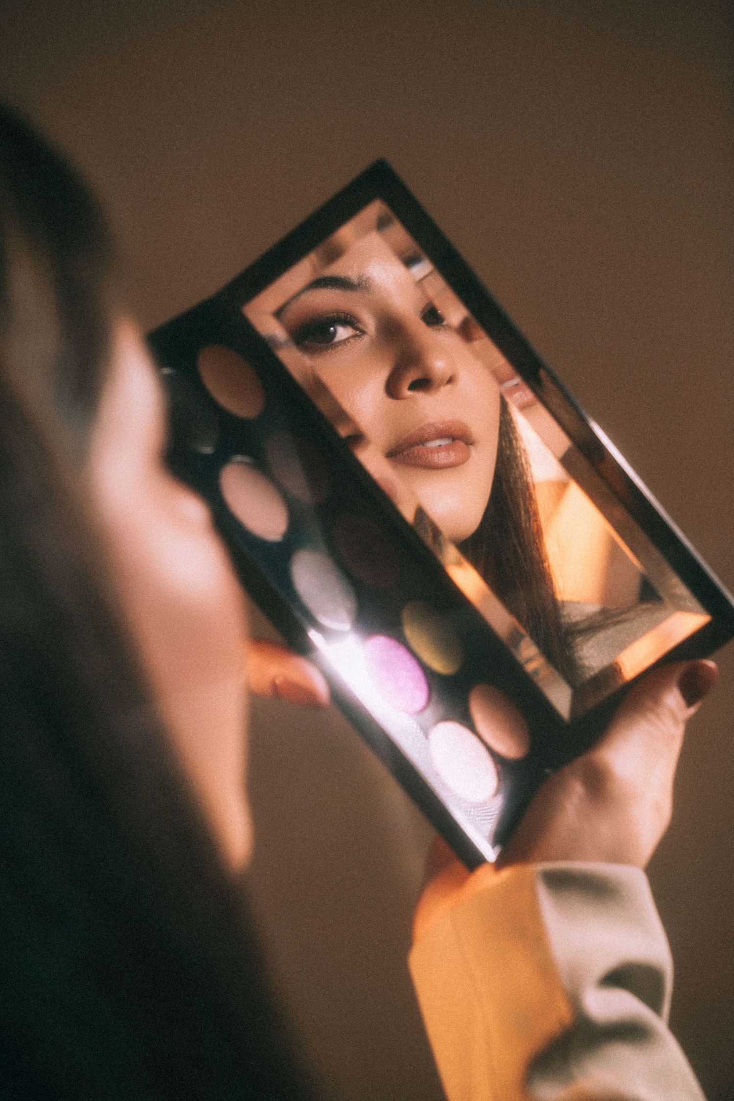 Artistic photo series showing reflections in handheld mirror with warm lighting.
