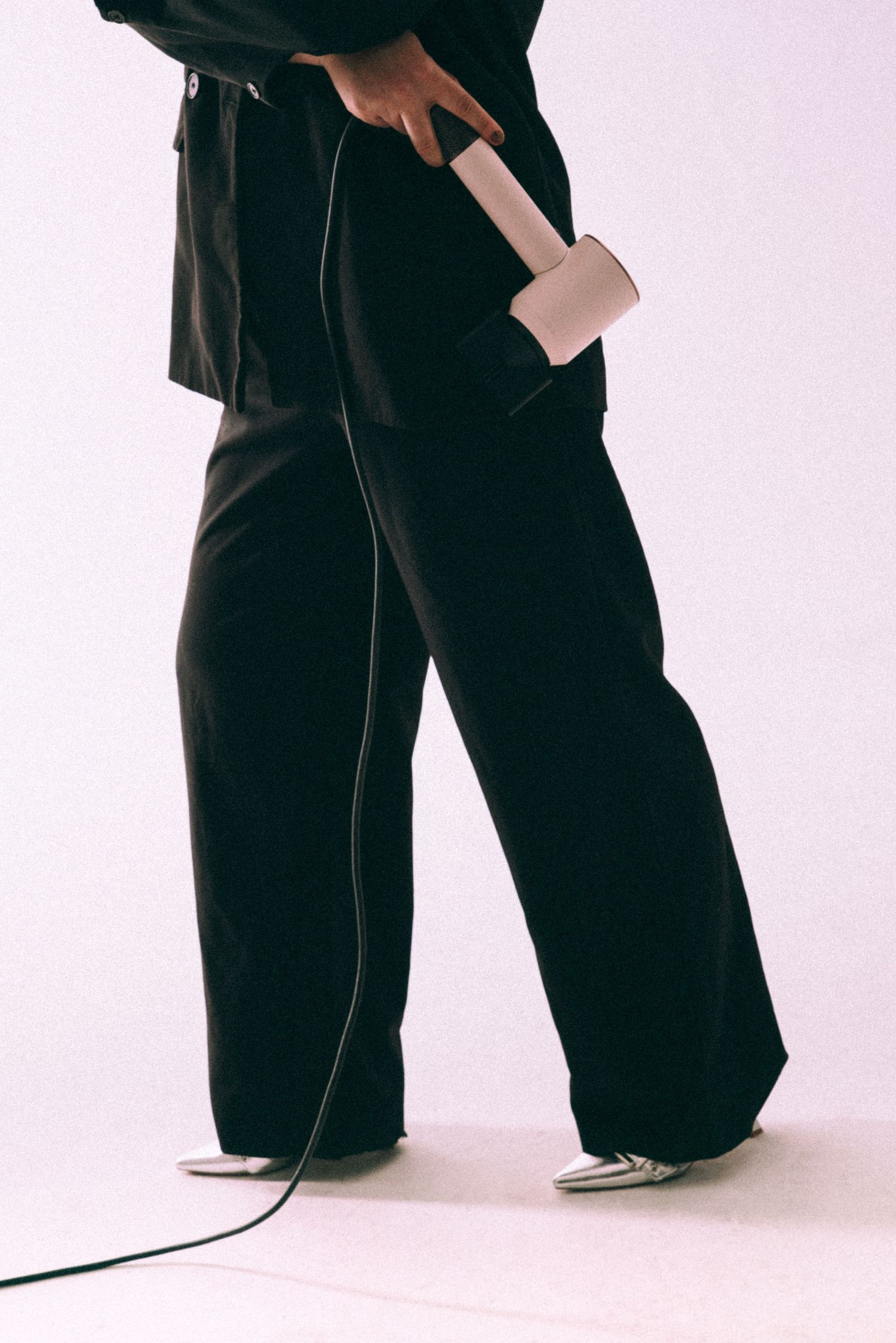 Minimalist fashion photo showing lower body in dark clothing.