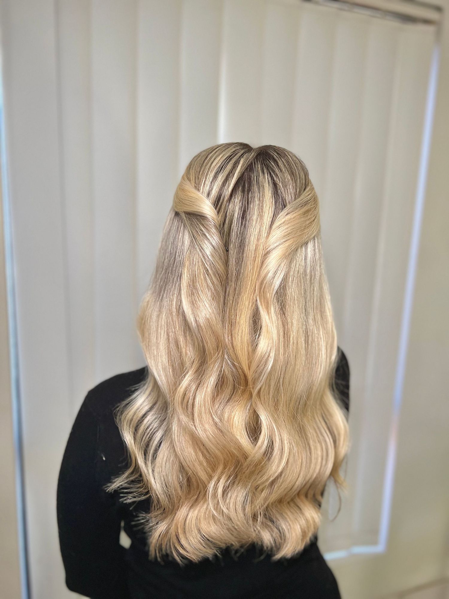 Blonde wavy hair transformation shown in four stages from a back view with black shirt.