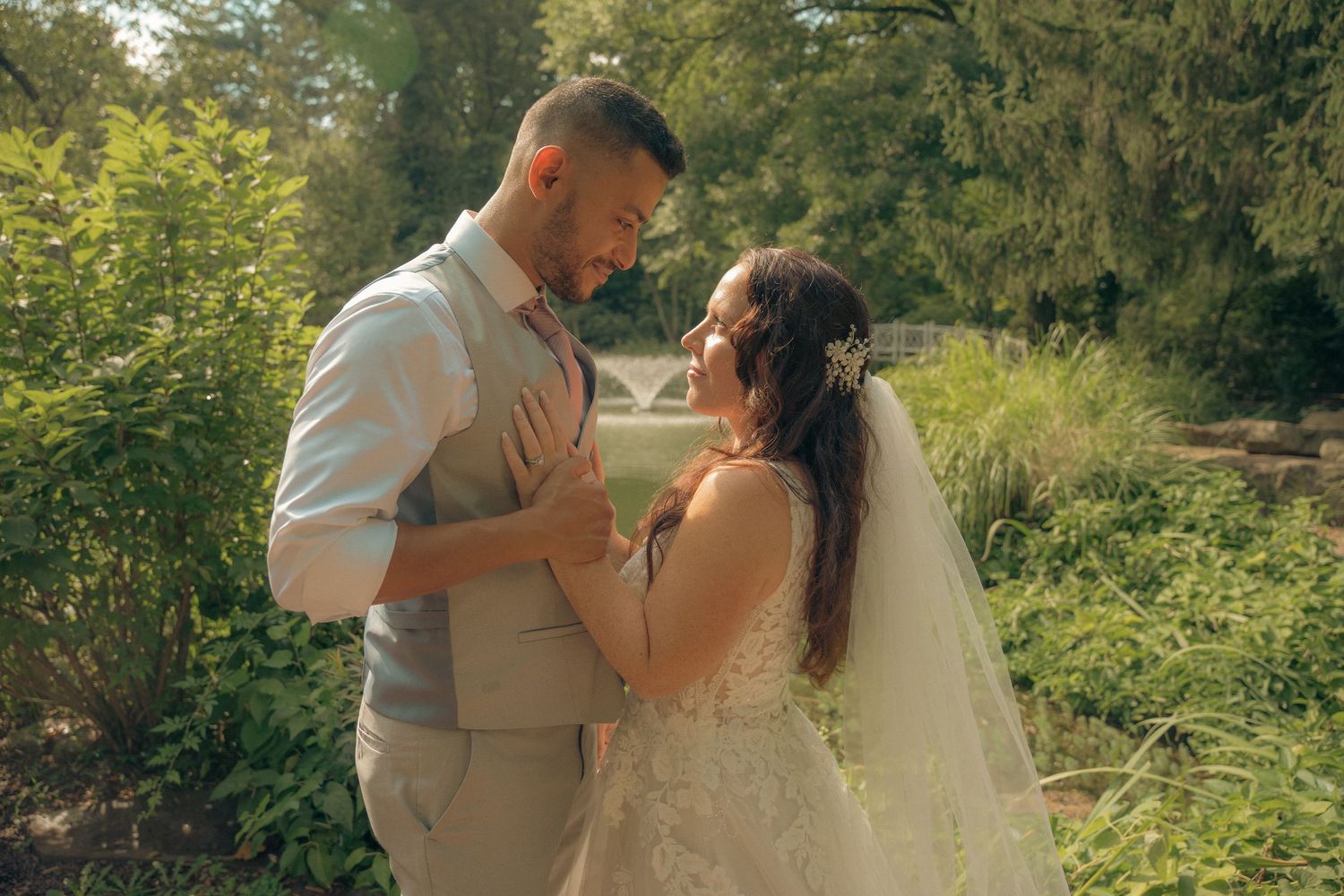 Bride and groom share a romantic moment in a lush garden setting on their wedding day.