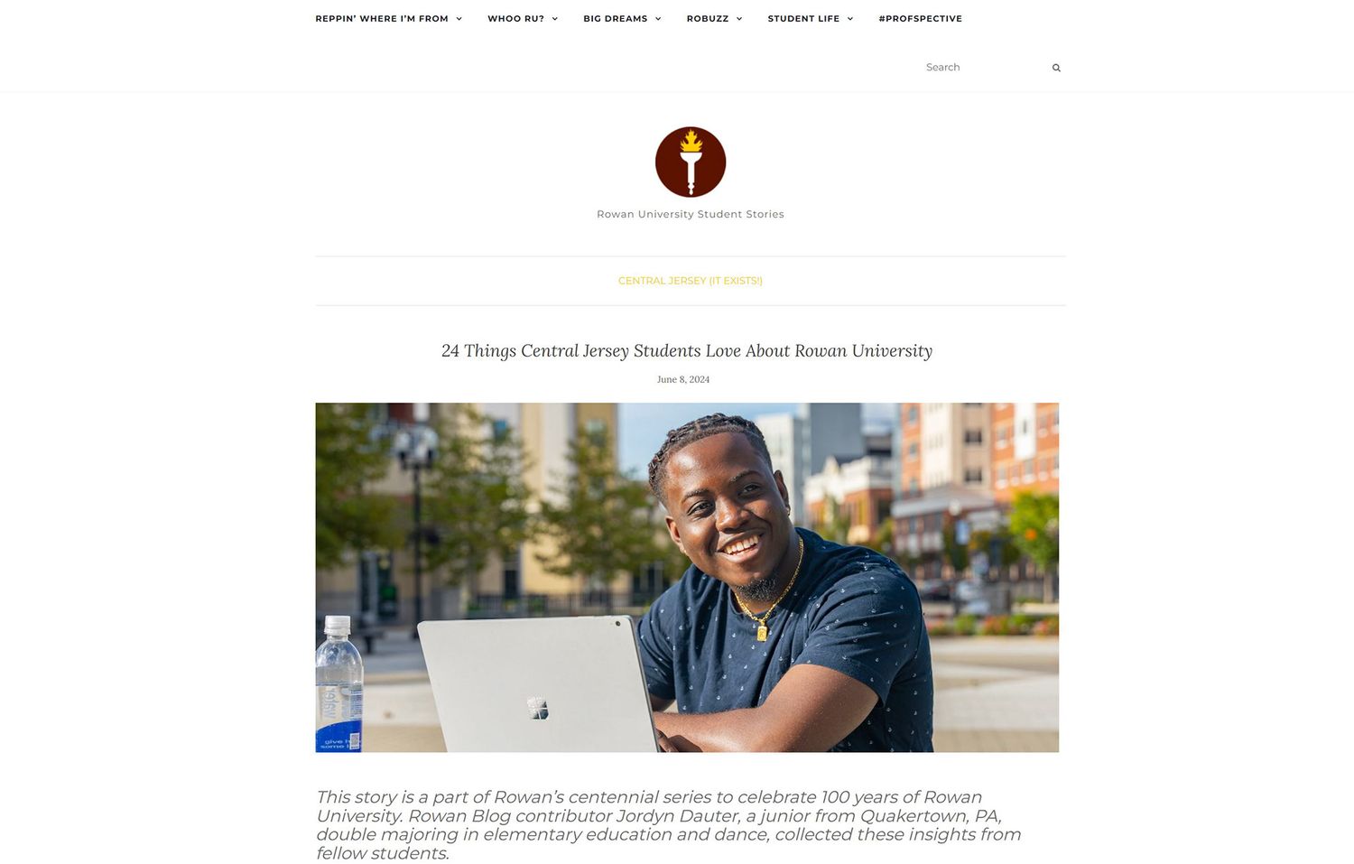 Smiling young male student sitting outdoors featured in a Rowan University centennial campus article.