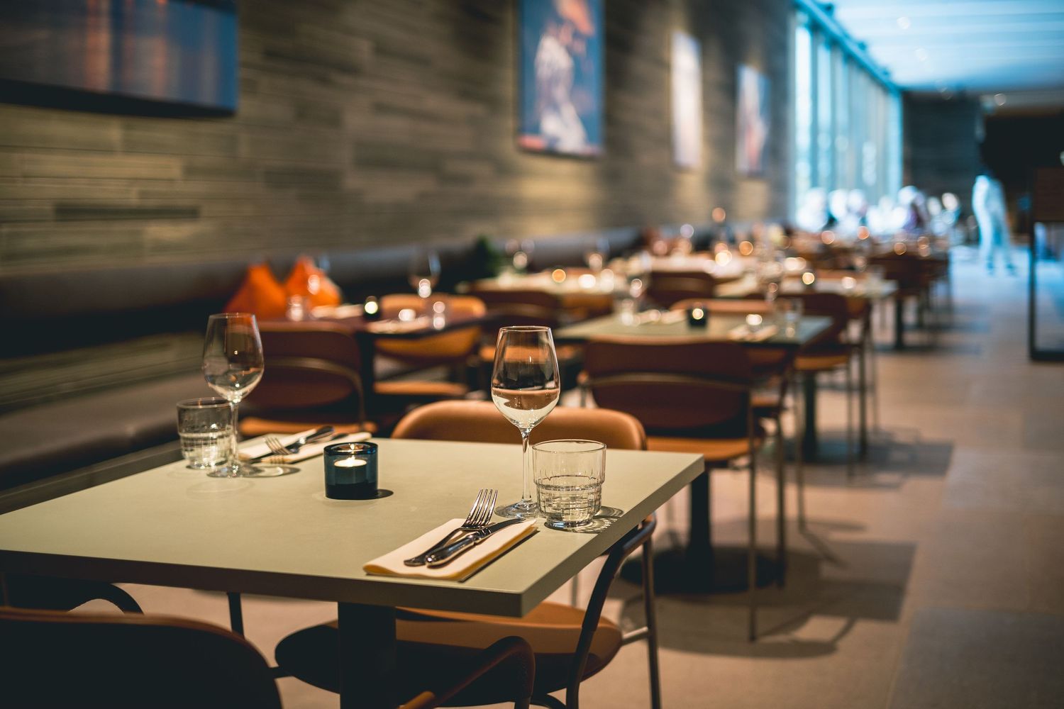 Modern restaurant interior with empty tables set for fine dining service.