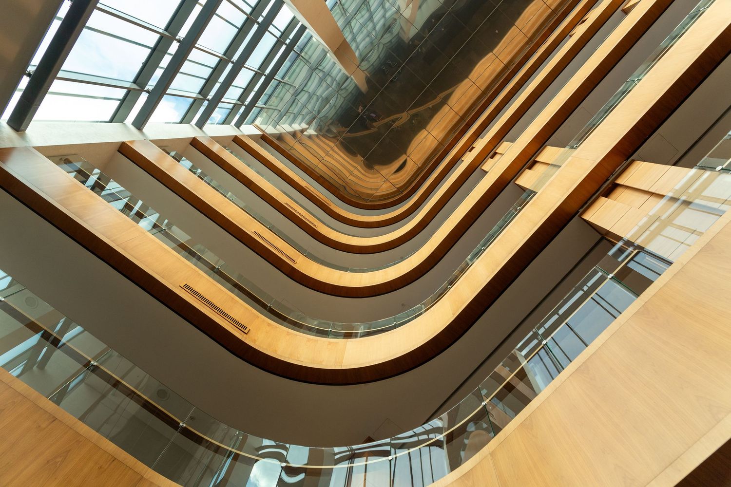 Modern architectural spiral staircase with wooden handrails and curved design elements.
