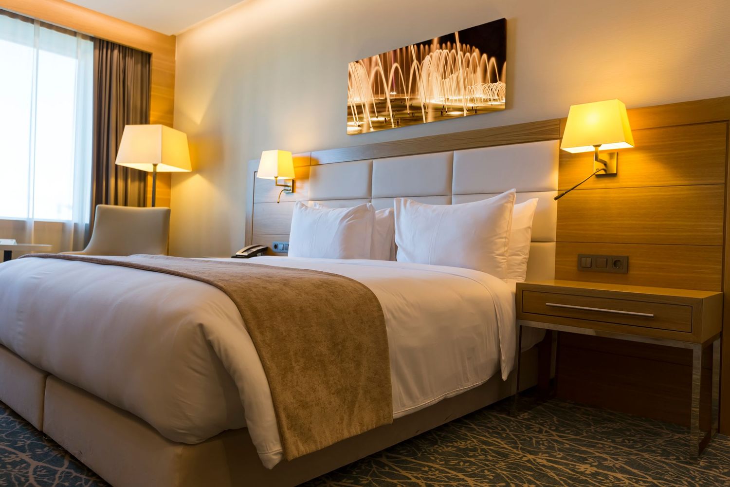 Warm and inviting hotel bedroom with ambient lighting and contemporary furnishings.