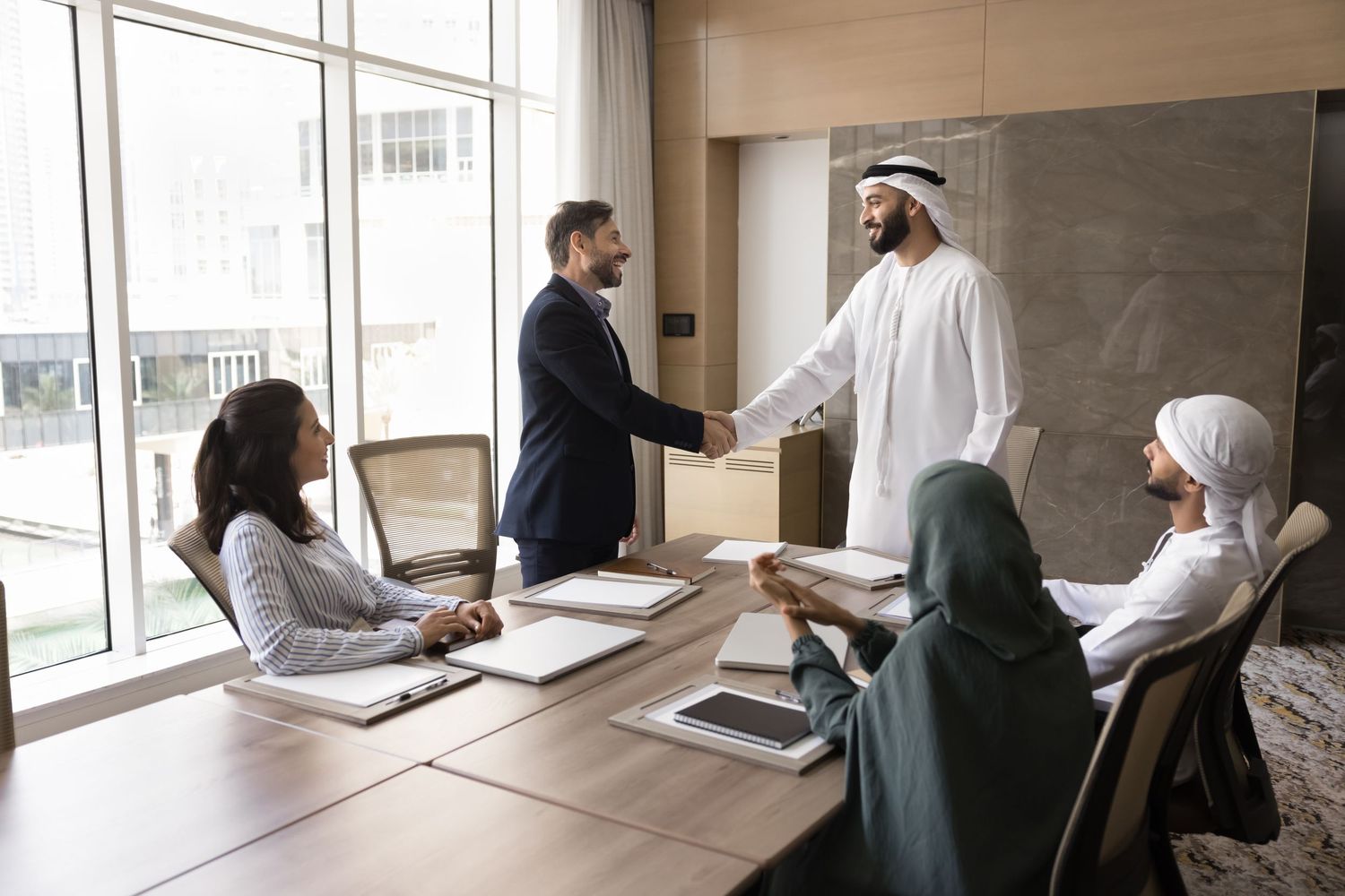 Business meeting in bright modern office with large windows and natural light.