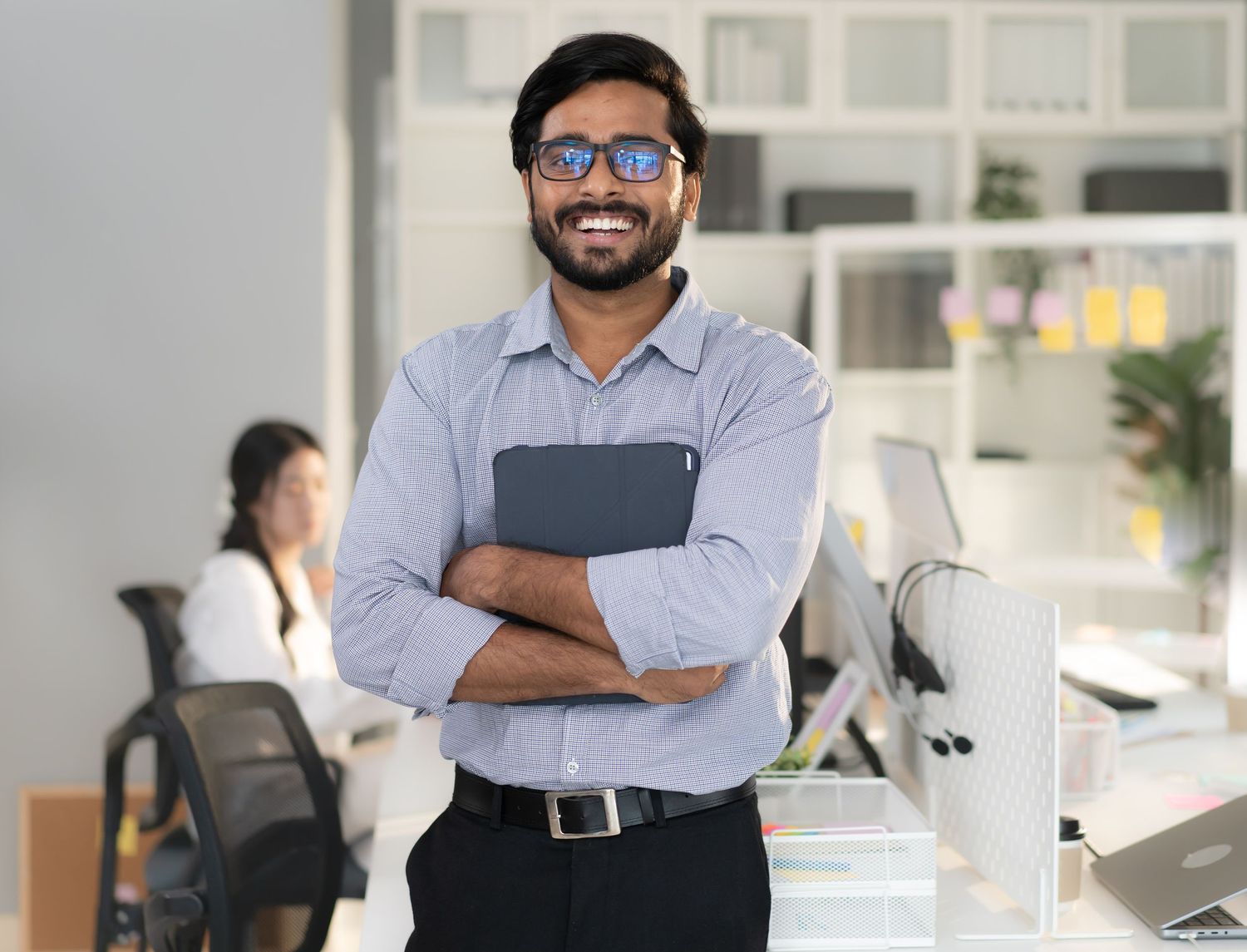 Office professionals stand in front of white cabinets in modern workplace.