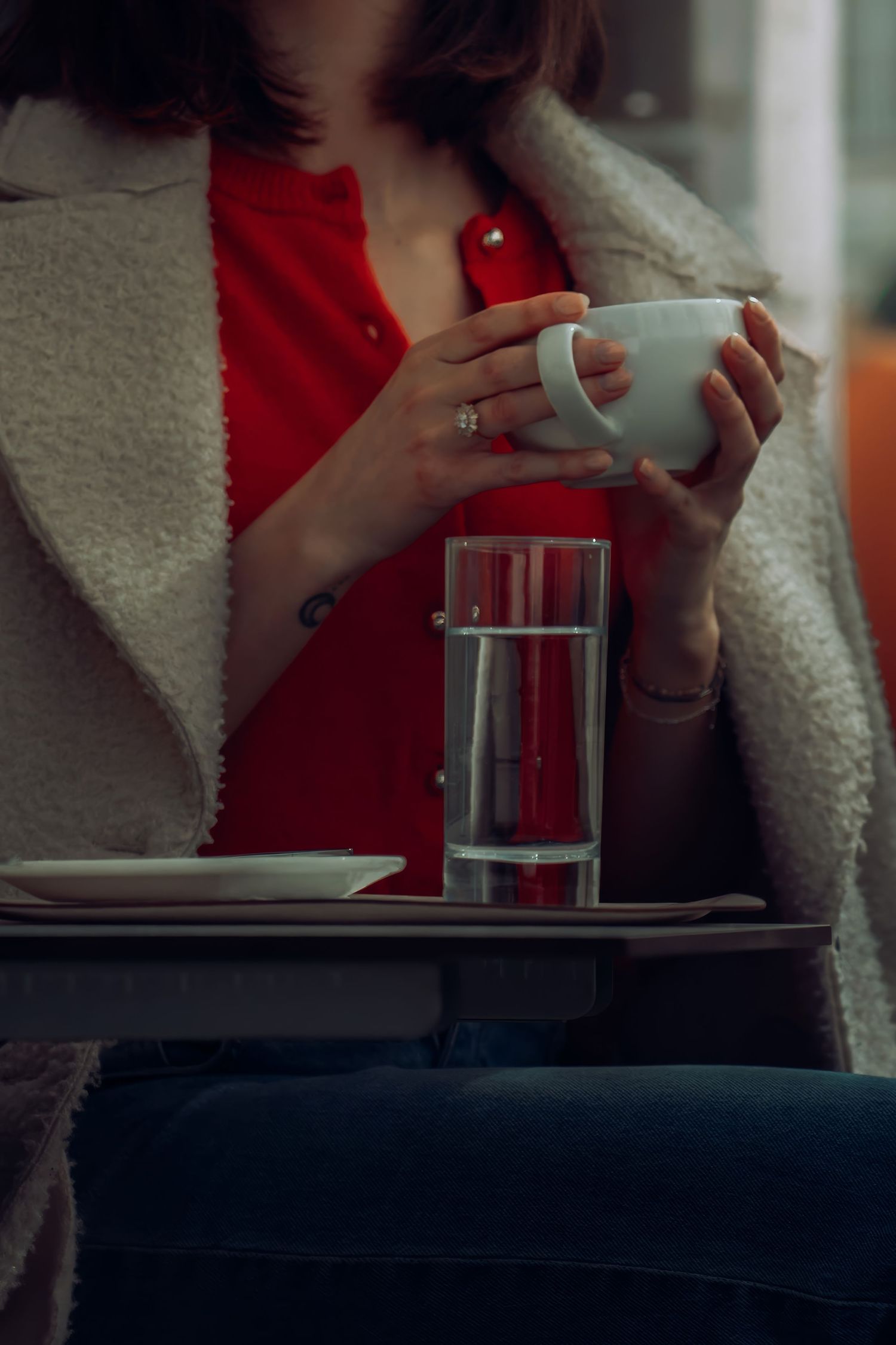 Sequence of someone in a red sweater drinking from a white coffee cup.