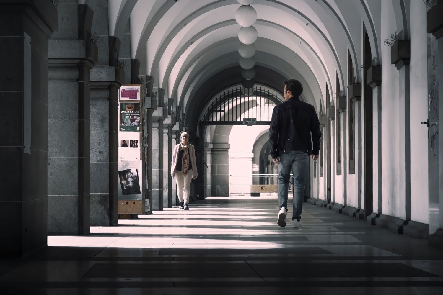 Long arched hallway with repeating columns and architectural details.