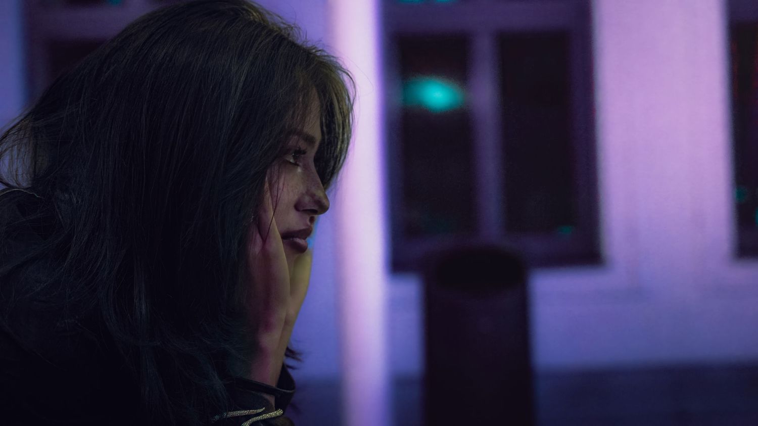 Profile silhouette with purple neon lighting in a dark interior space.