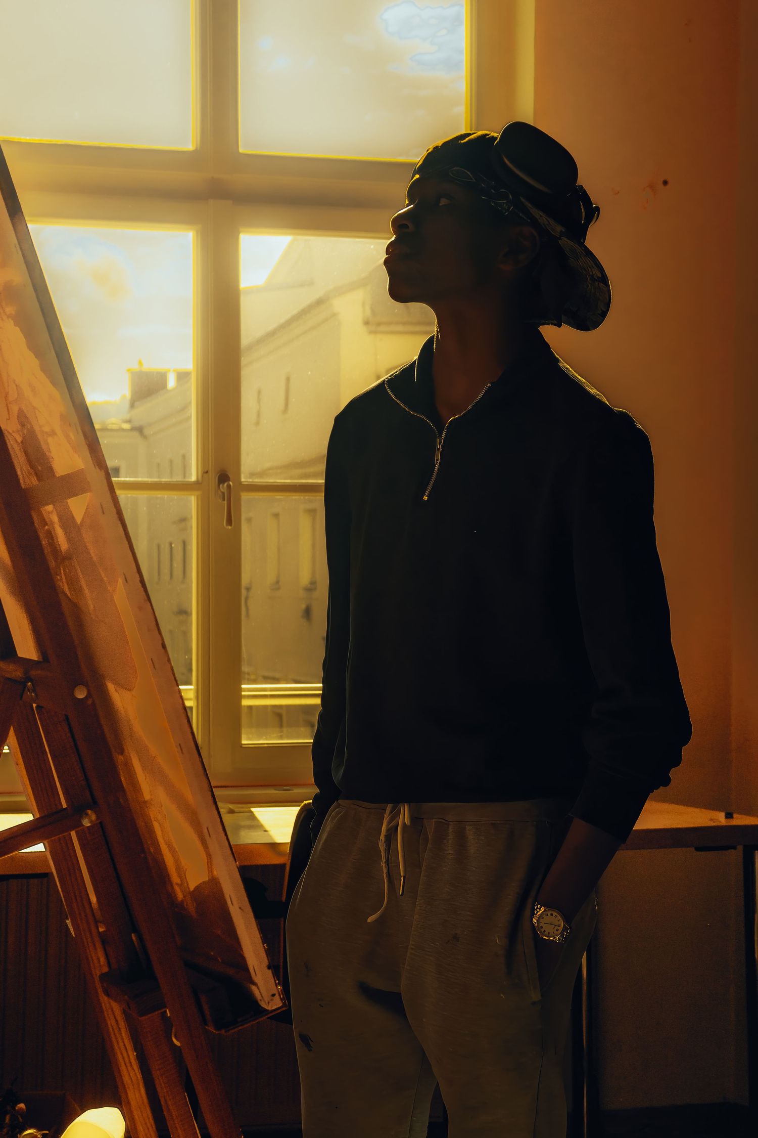 Silhouette against warm window light in artistic composition.