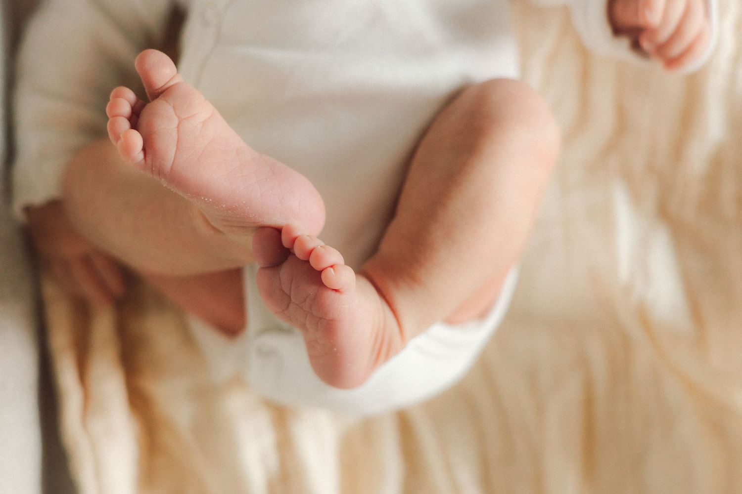 At home newborn photography on bed. Crested Butte, Colorado close up of feet