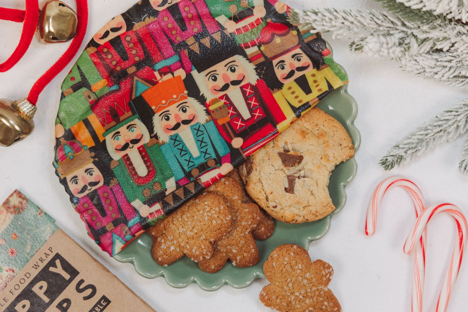 Festive gingerbread cookies decorated with colorful icing and candy canes arranged on a white lace doily.