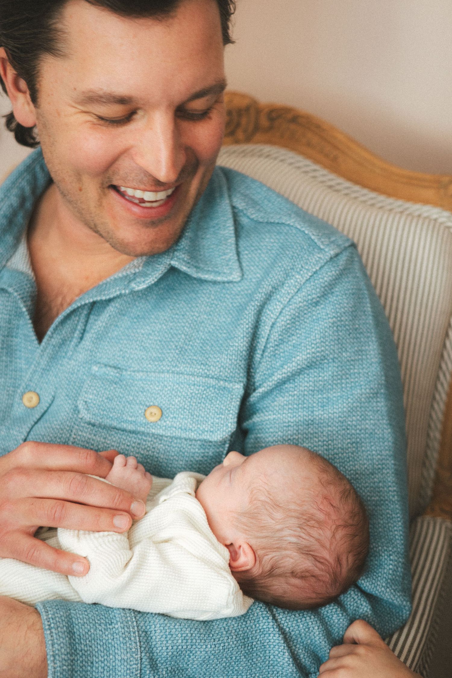 A series of photos showing tender moments between a parent in a blue shirt and a newborn baby.
