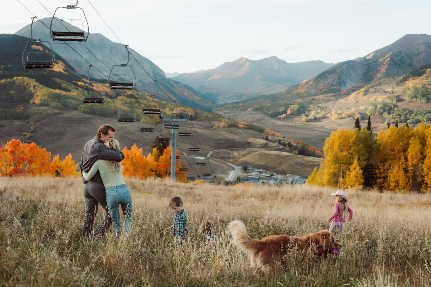 A scenic mountain engagement photo session with golden autumn foliage and rolling hills in the background.