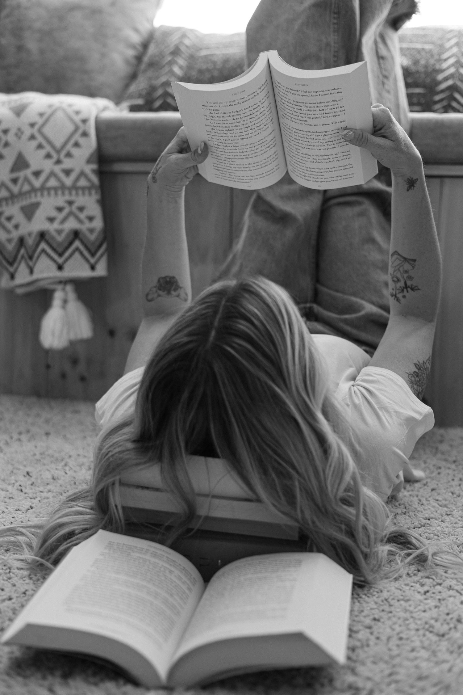 A series of black and white photos showing someone lying on a carpet reading a book in different positions.