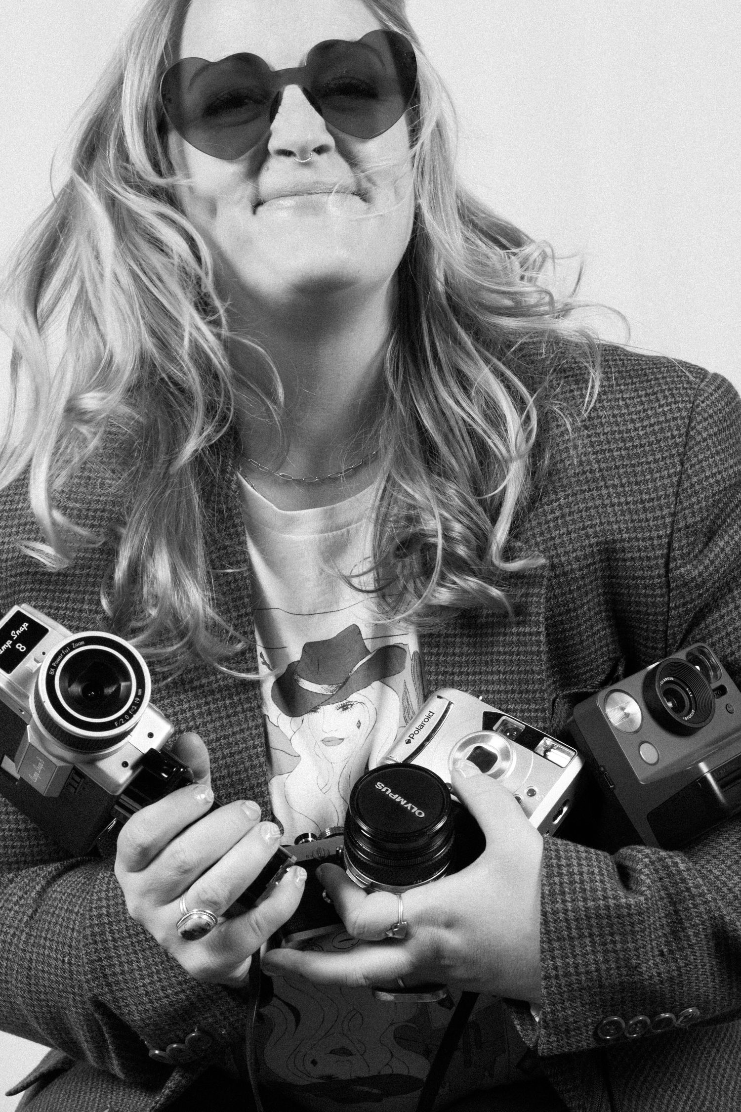 Black and white photo series showing hands holding vintage film cameras against a light background.