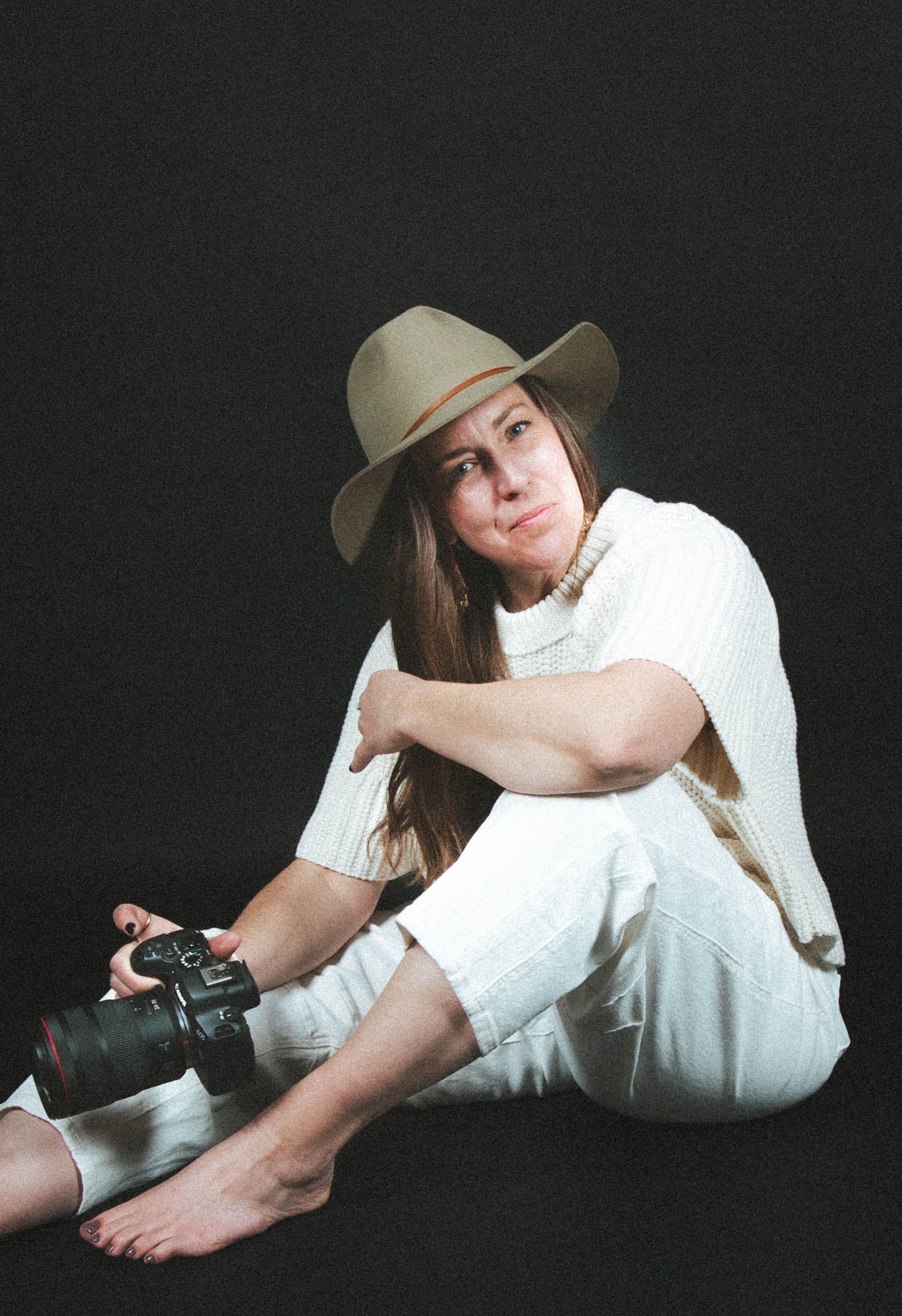 Artistic portrait series showing a person in white clothing and beige hat reclining against dark background. Crested Butte