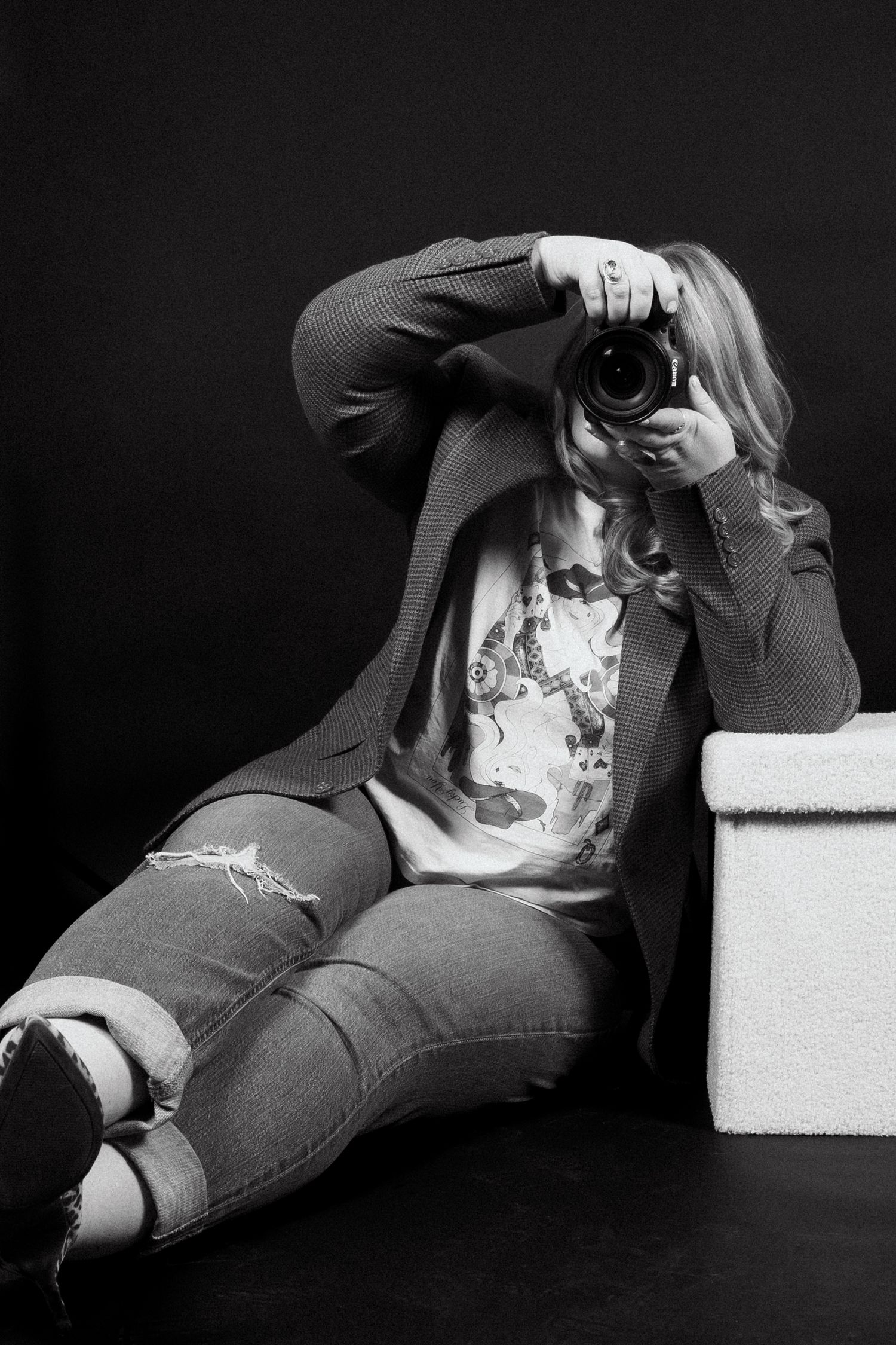 Black and white artistic photo series showing person in casual clothing reclining on geometric white blocks against dark background.