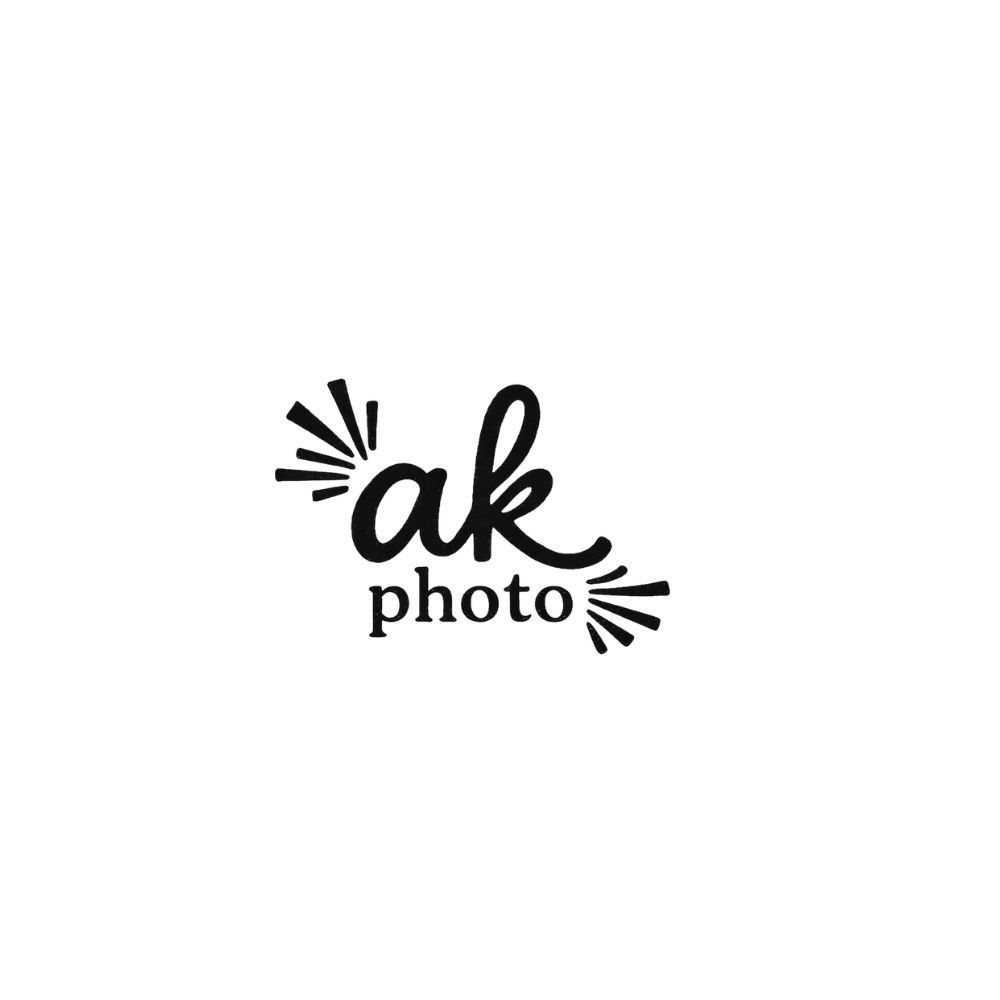 Black and white logo for AK Photo featuring stylish handwritten text with decorative burst lines on a white background.