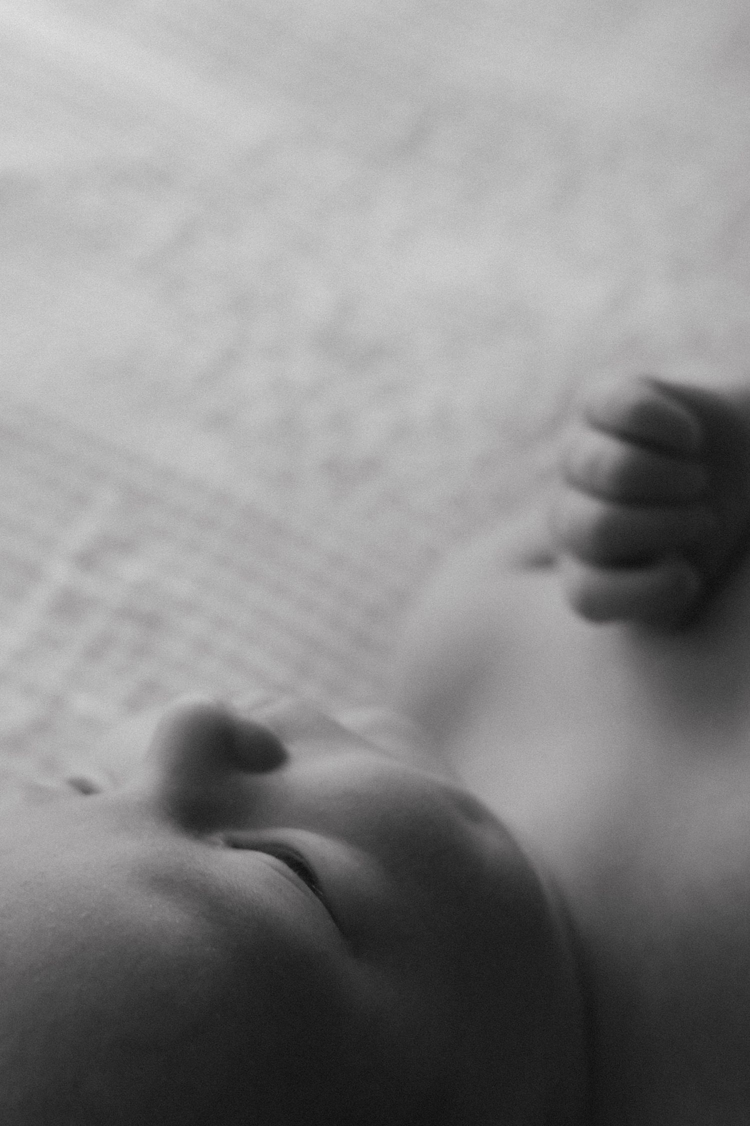 A blurred black and white close-up photograph showing abstract motion and shadows with a textured surface in focus.