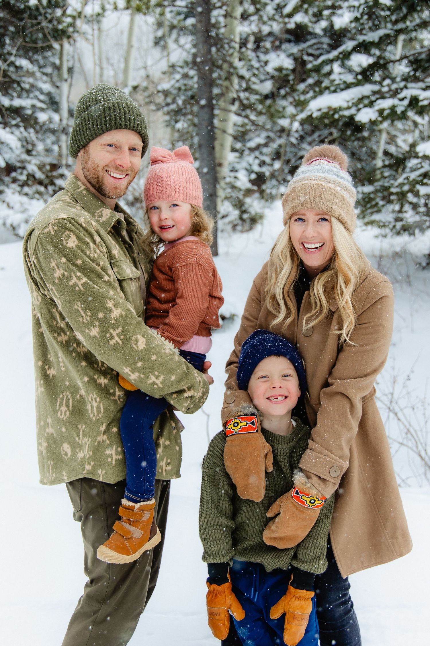A group of candid winter photos showing playful moments in the snow with warm winter clothing and evergreen trees.