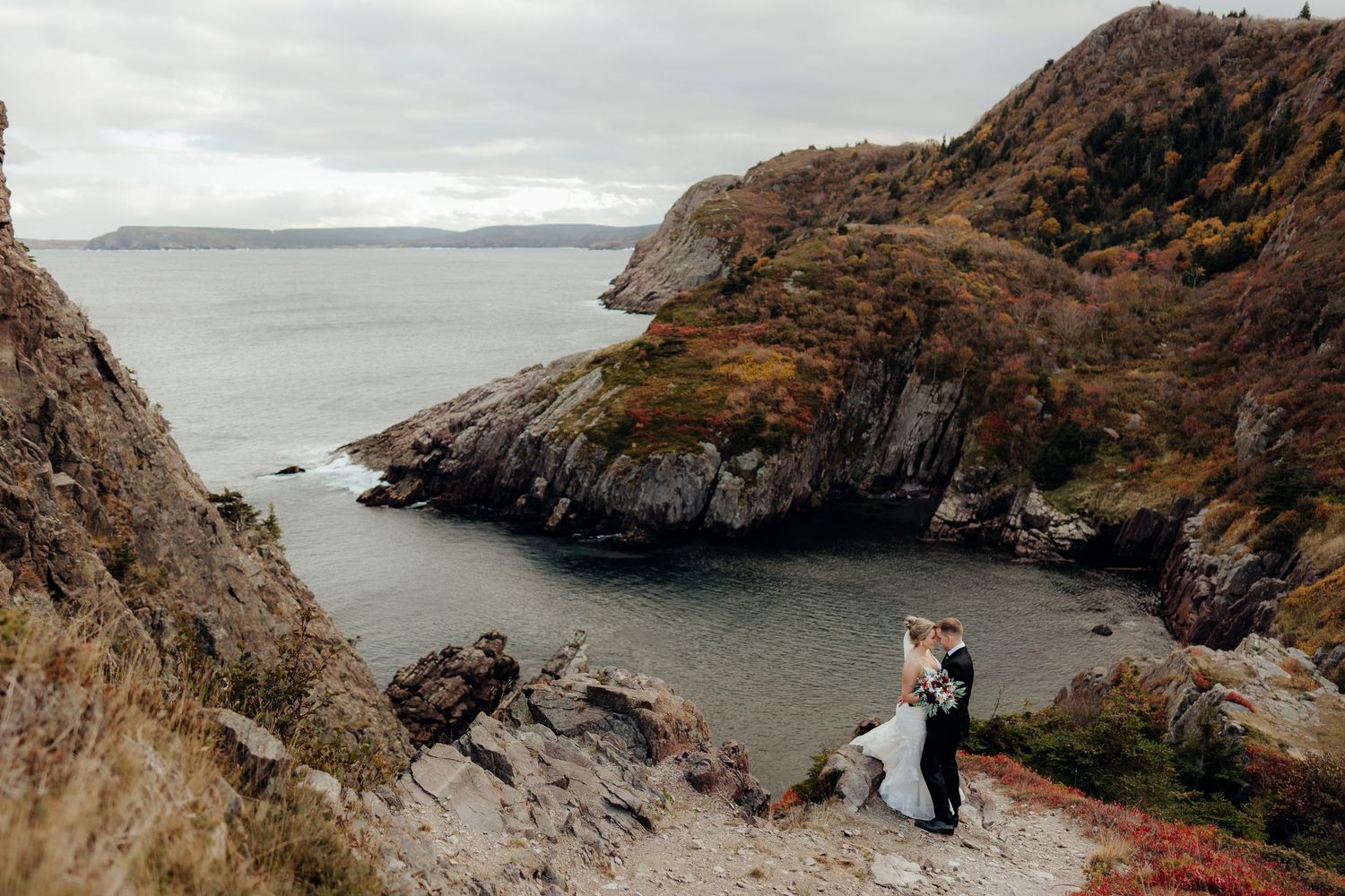 Panoramic view of a wedding ceremony location on rugged coastal cliffs.