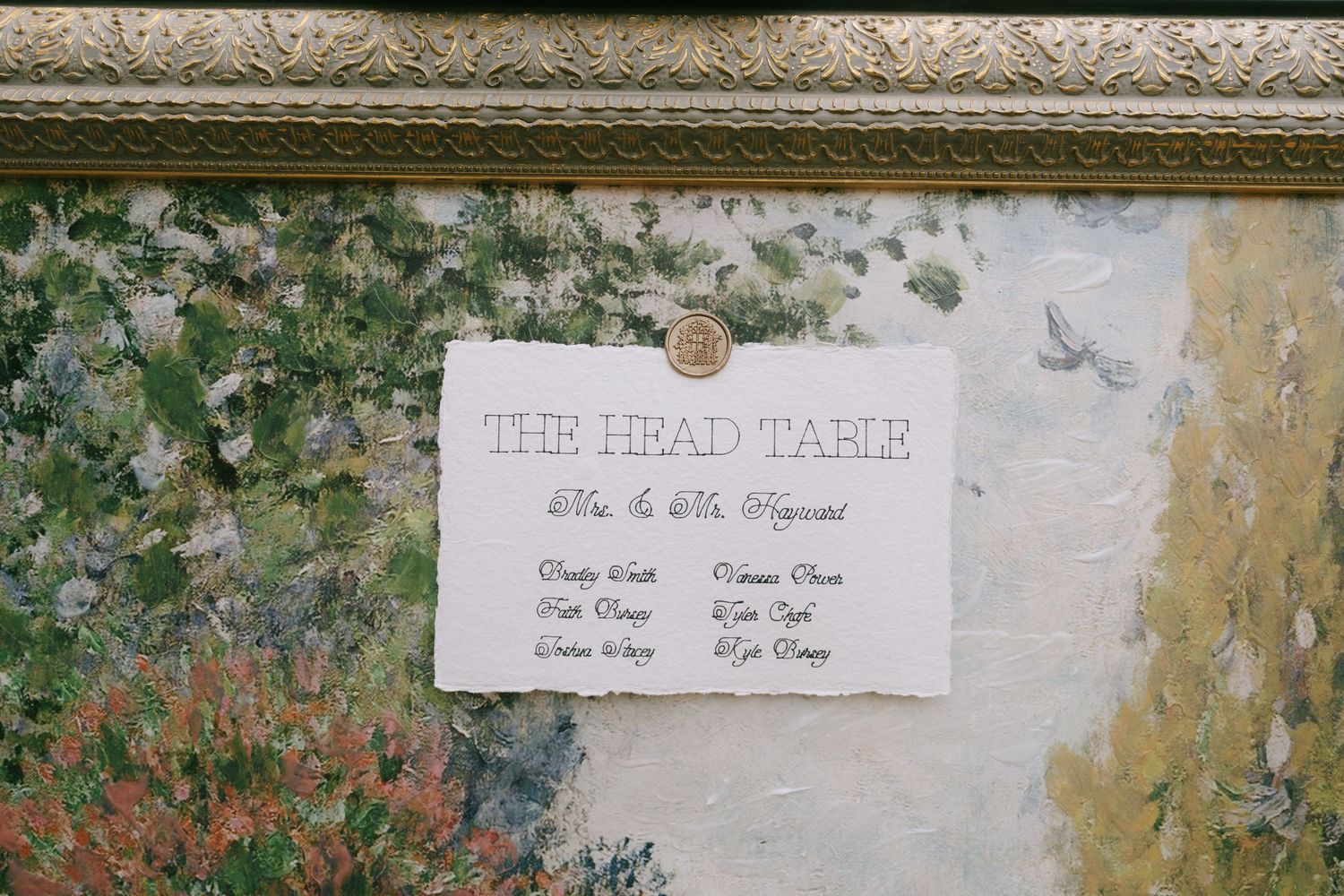 A white name card display with elegant text mounted on a textured wall.