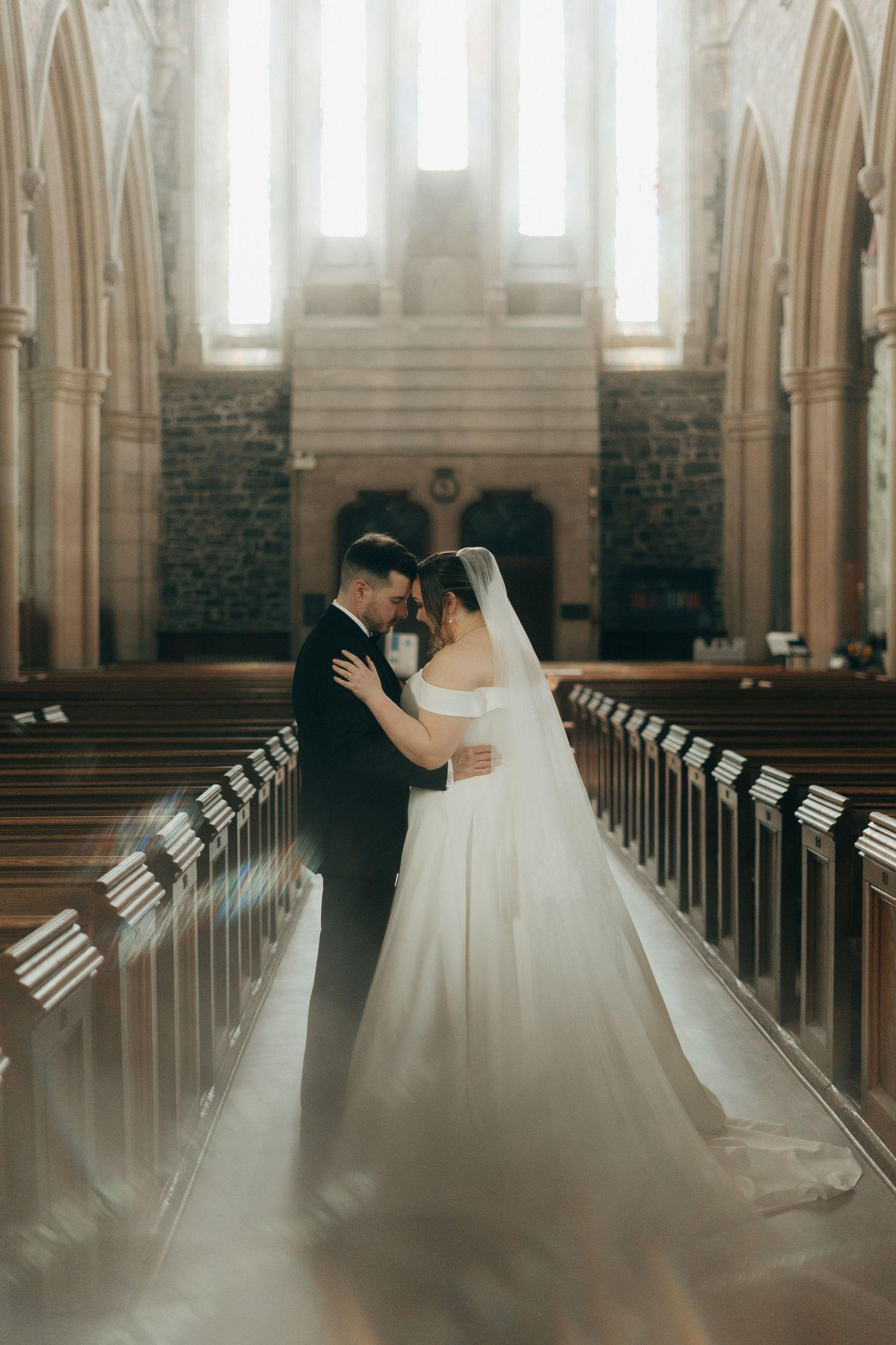 Cathedral wedding photography with dramatic lighting and gothic architectural details.