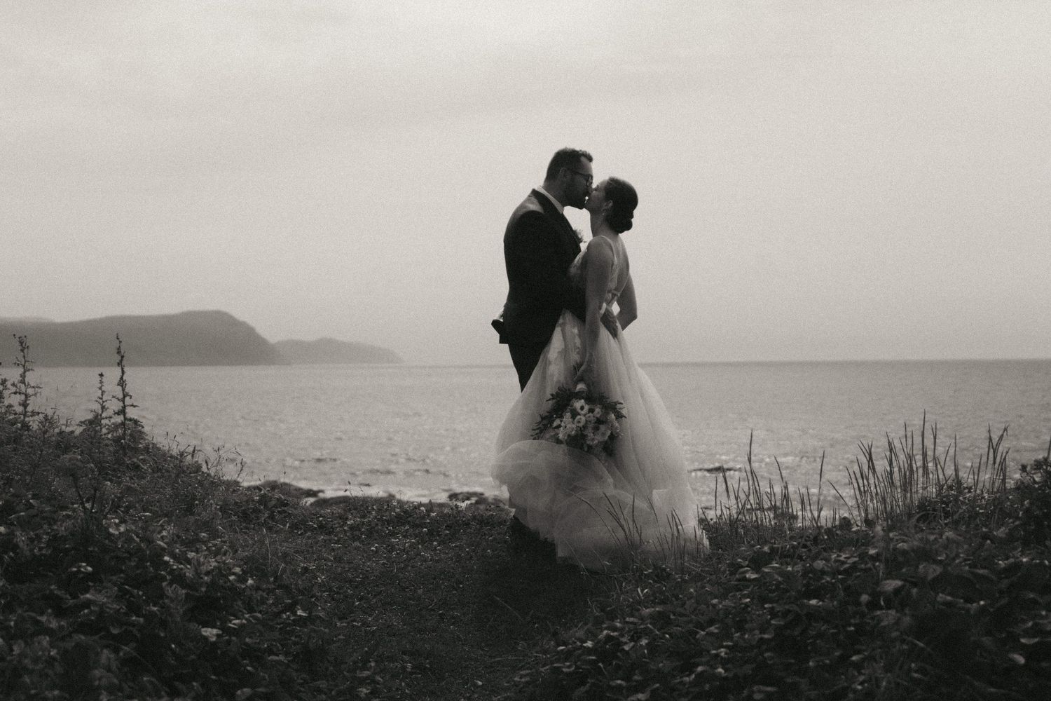 A series of romantic black and white coastal wedding photos featuring silhouettes against dramatic ocean landscapes.