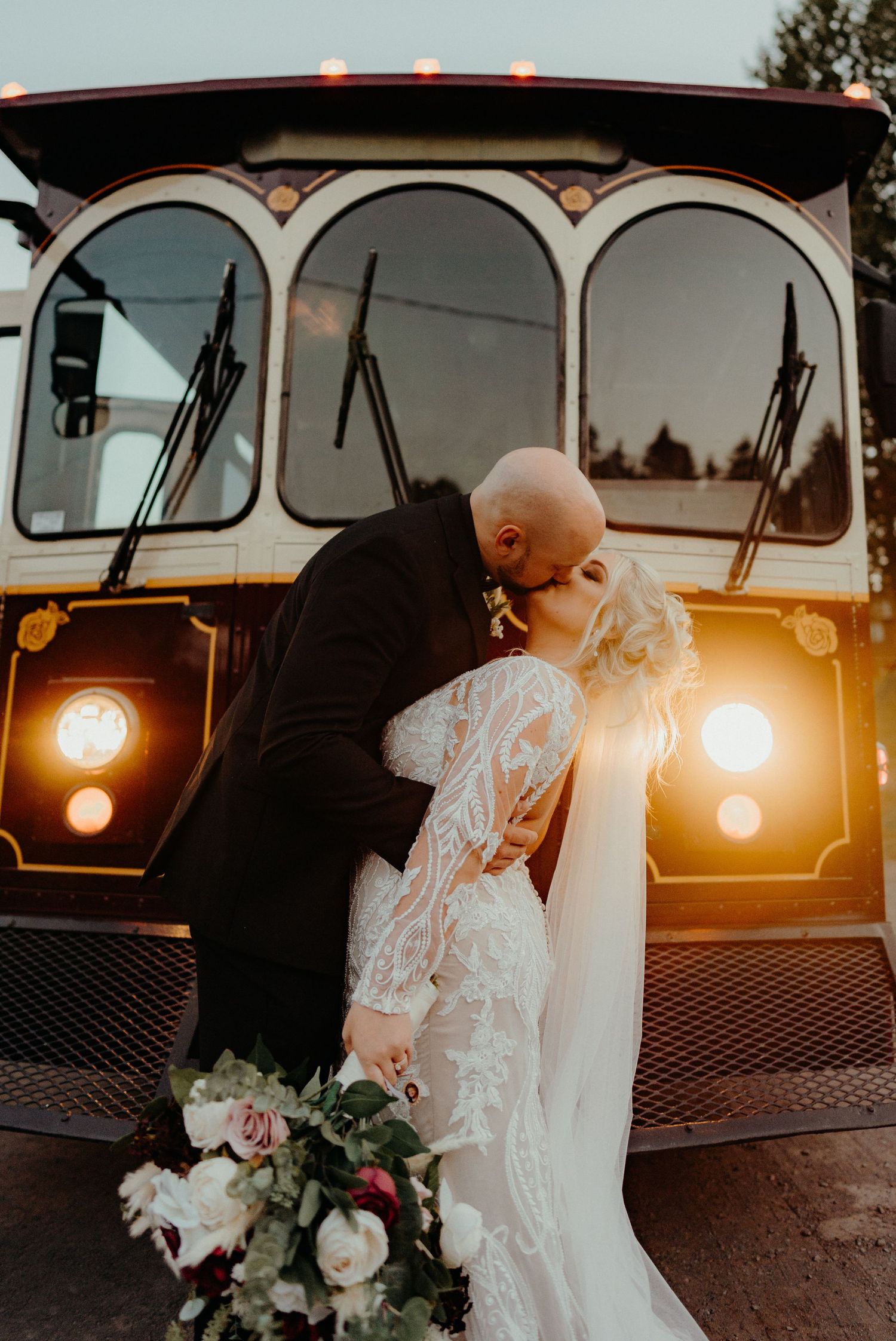 Vintage car photoshoot at sunset with romantic lighting and floral bouquet.