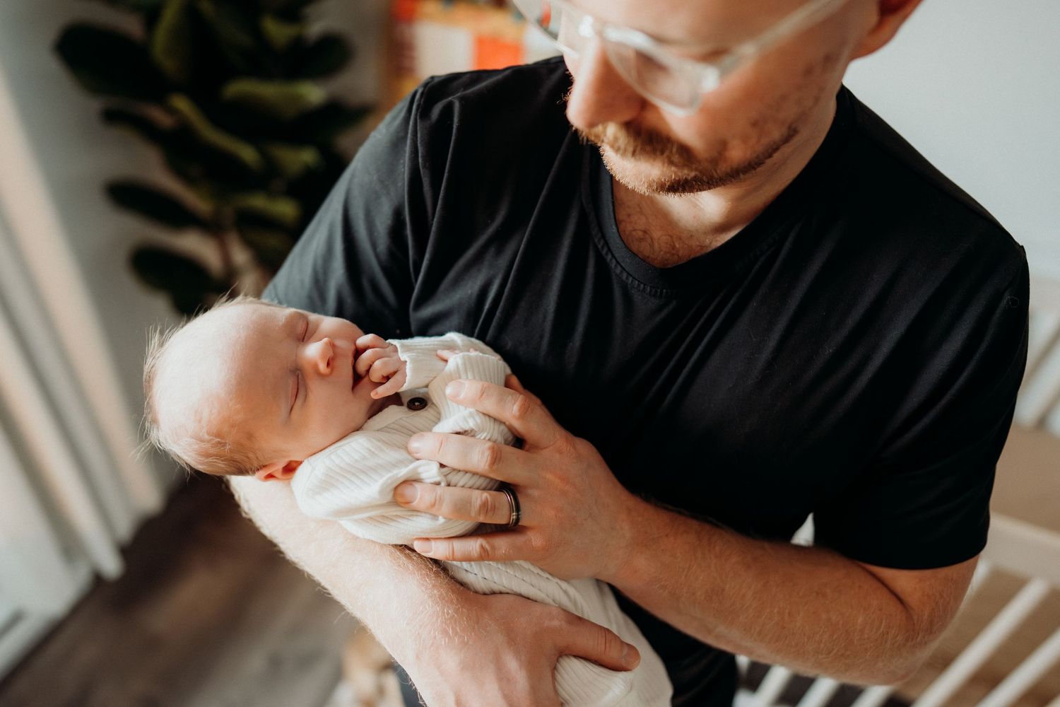 Candid moment of caregiver cradling newborn in nursery setting.