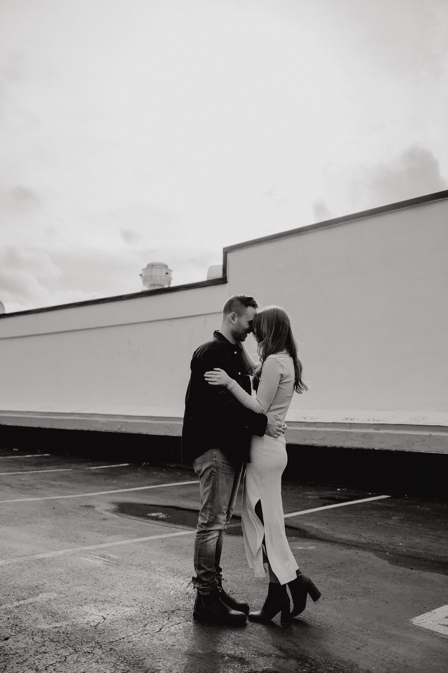 An intimate moment captured in black and white against a geometric architectural backdrop.